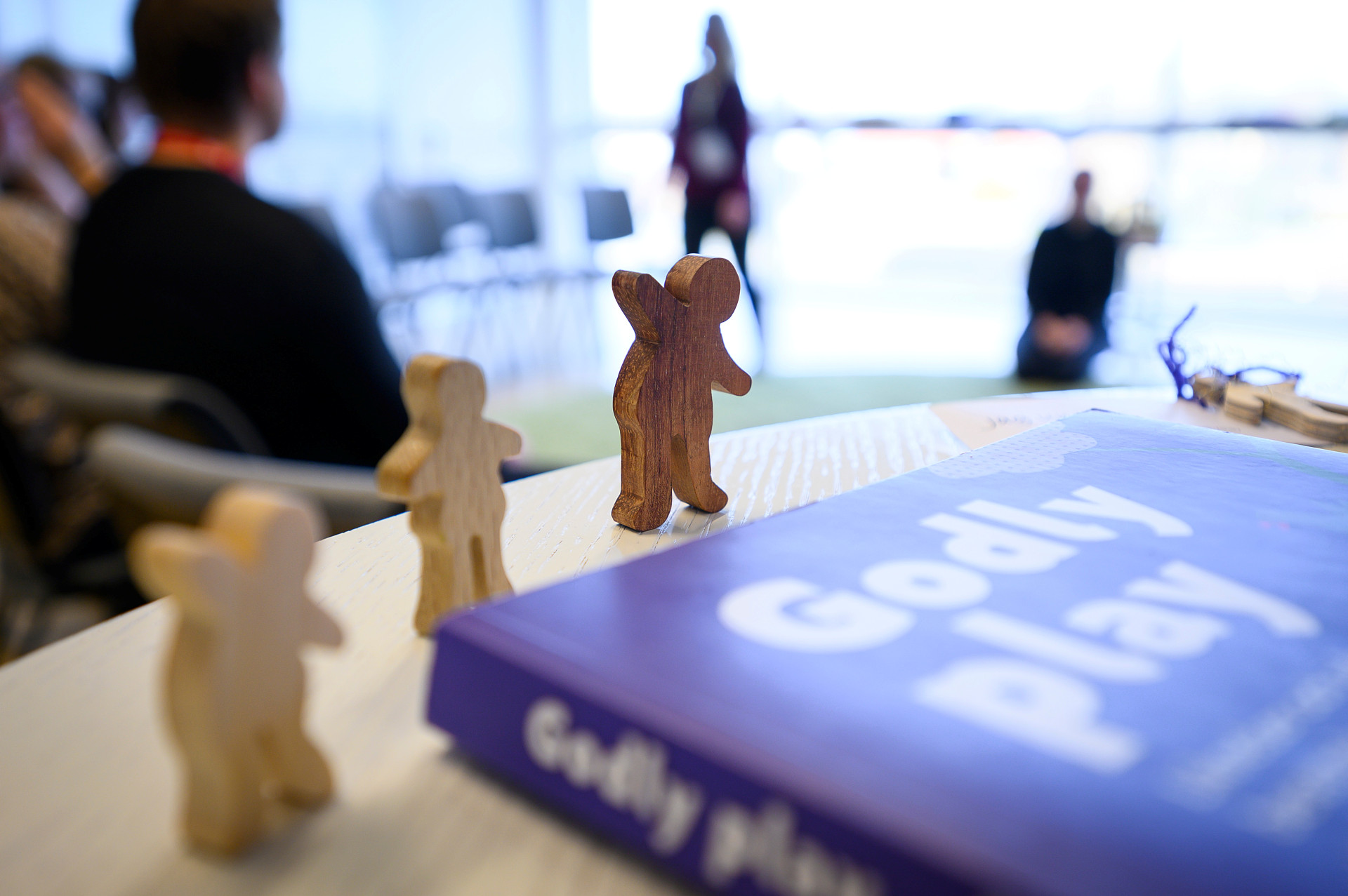 En bok med titeln Godly Play och figurer i trä.