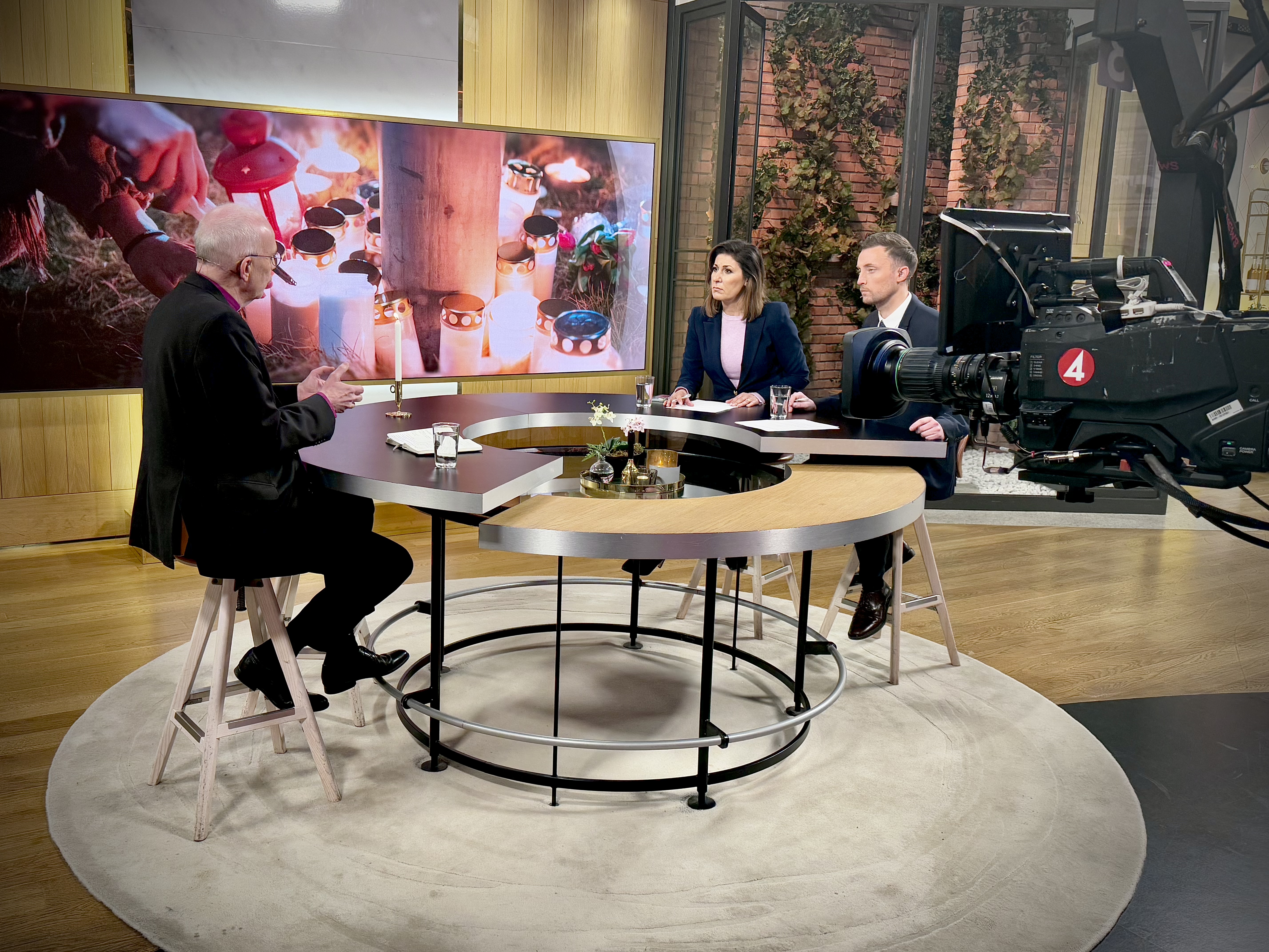 Två män och en kvinna sitter vid ett runt bord i en tv-studio.