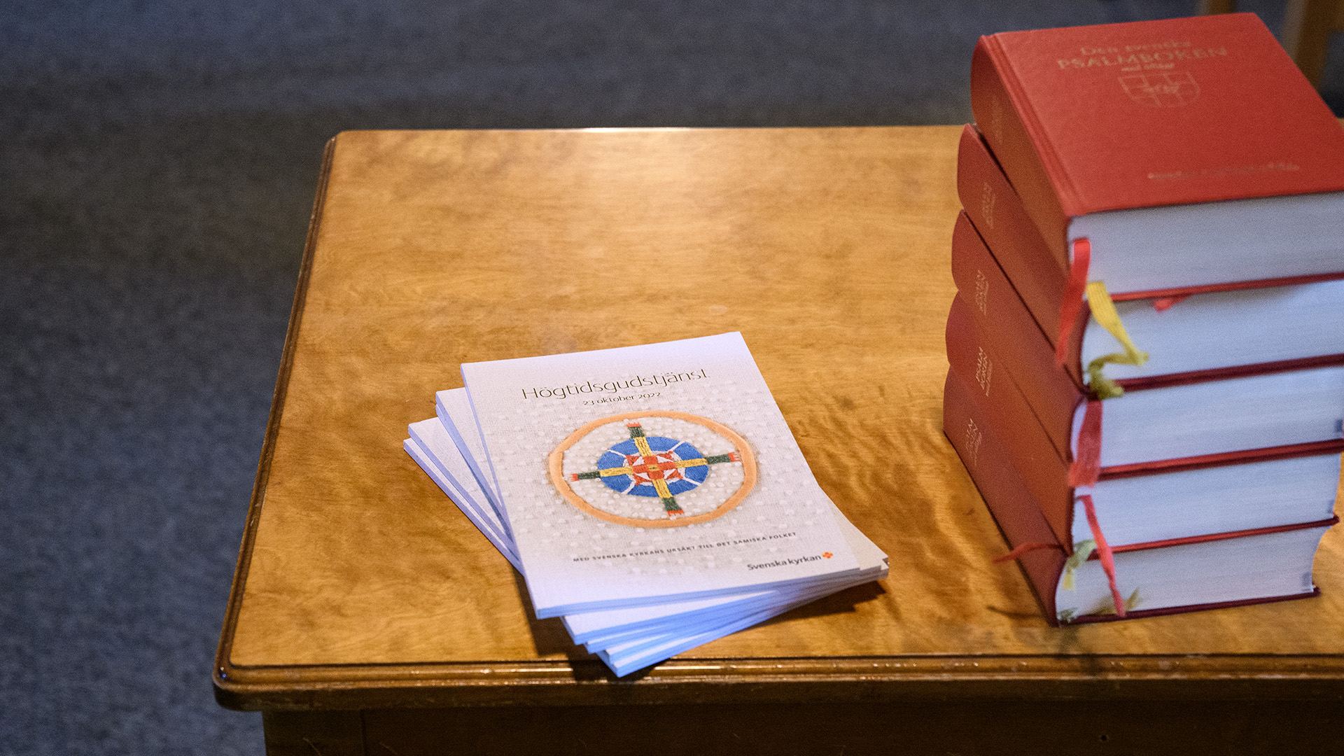agendor för gudstjänst ligger på ett bord med psalmböcker
