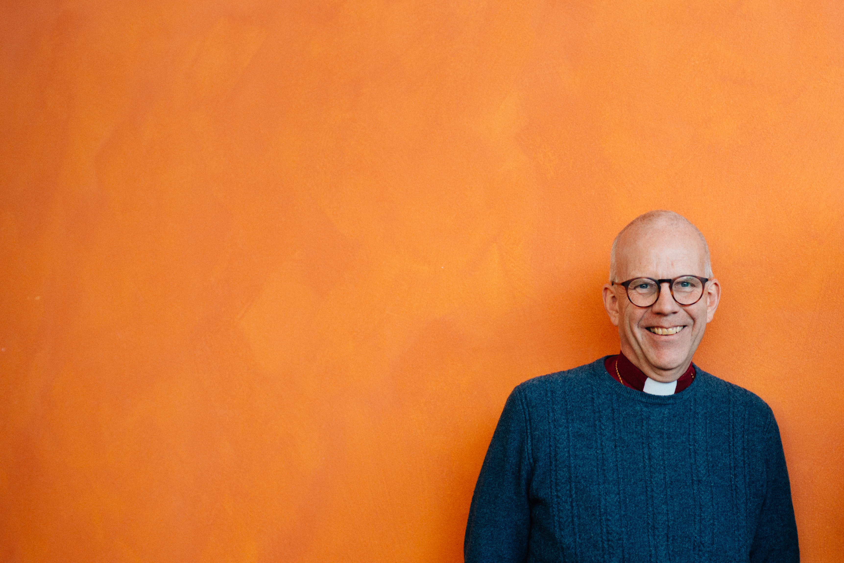 Martin Modéus i halvfigur framför en orange vägg.