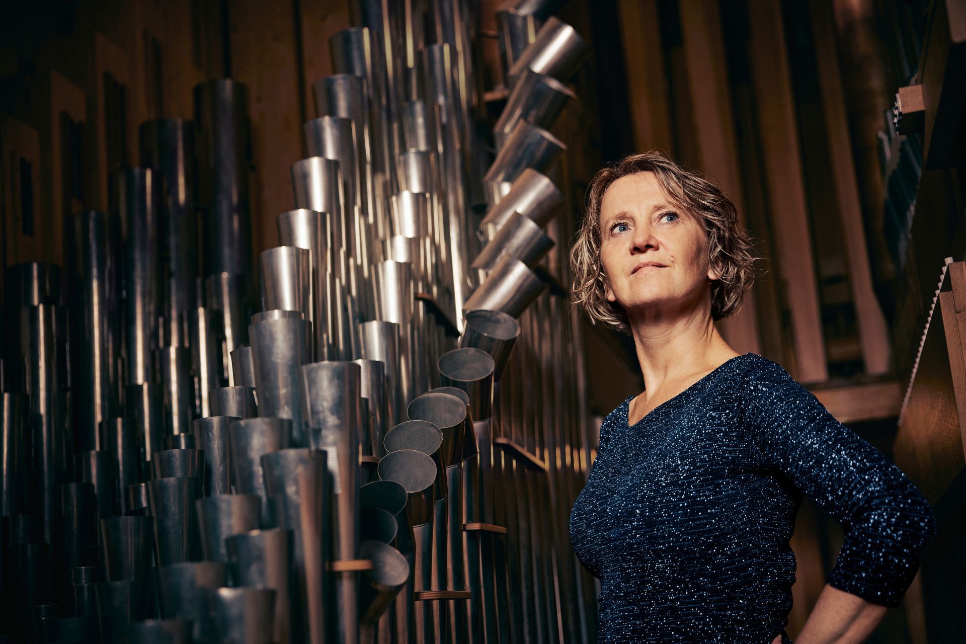 Bild på Hanne Kuhlmann bredvid en orgel.