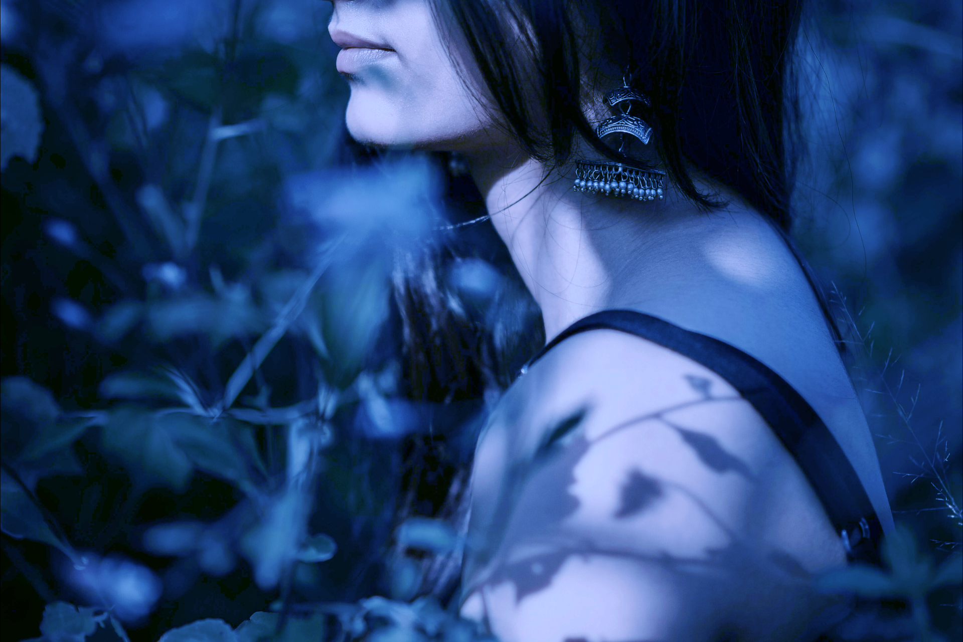 Konstnärlig bild av en person i profil. Bilden går i blåa toner och skuggor.