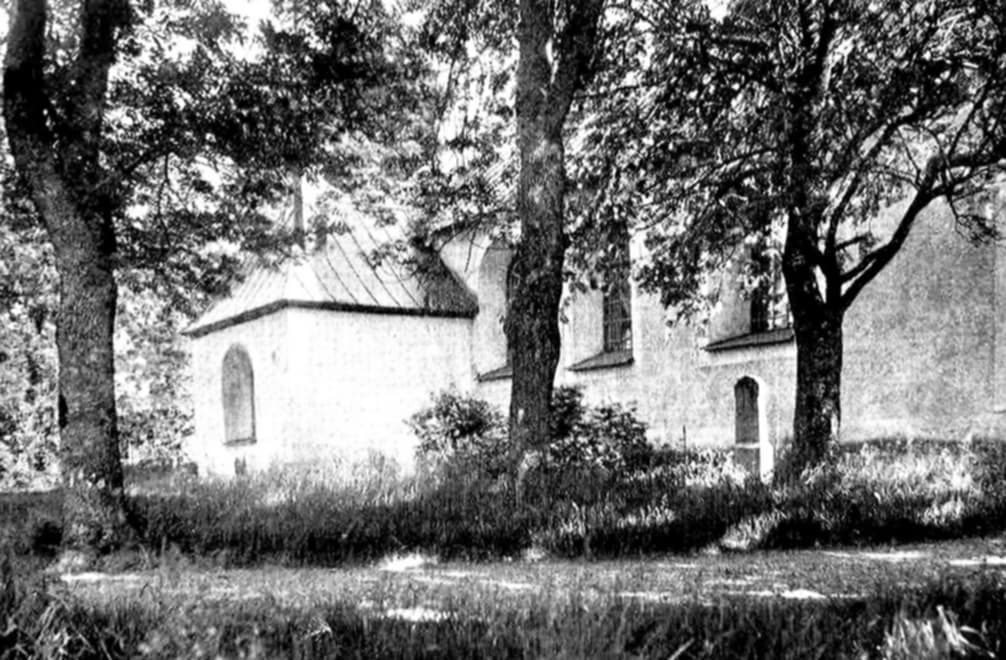 Svartvit bild +tre träd framför vit kyrka (Östhammars kyrka). 