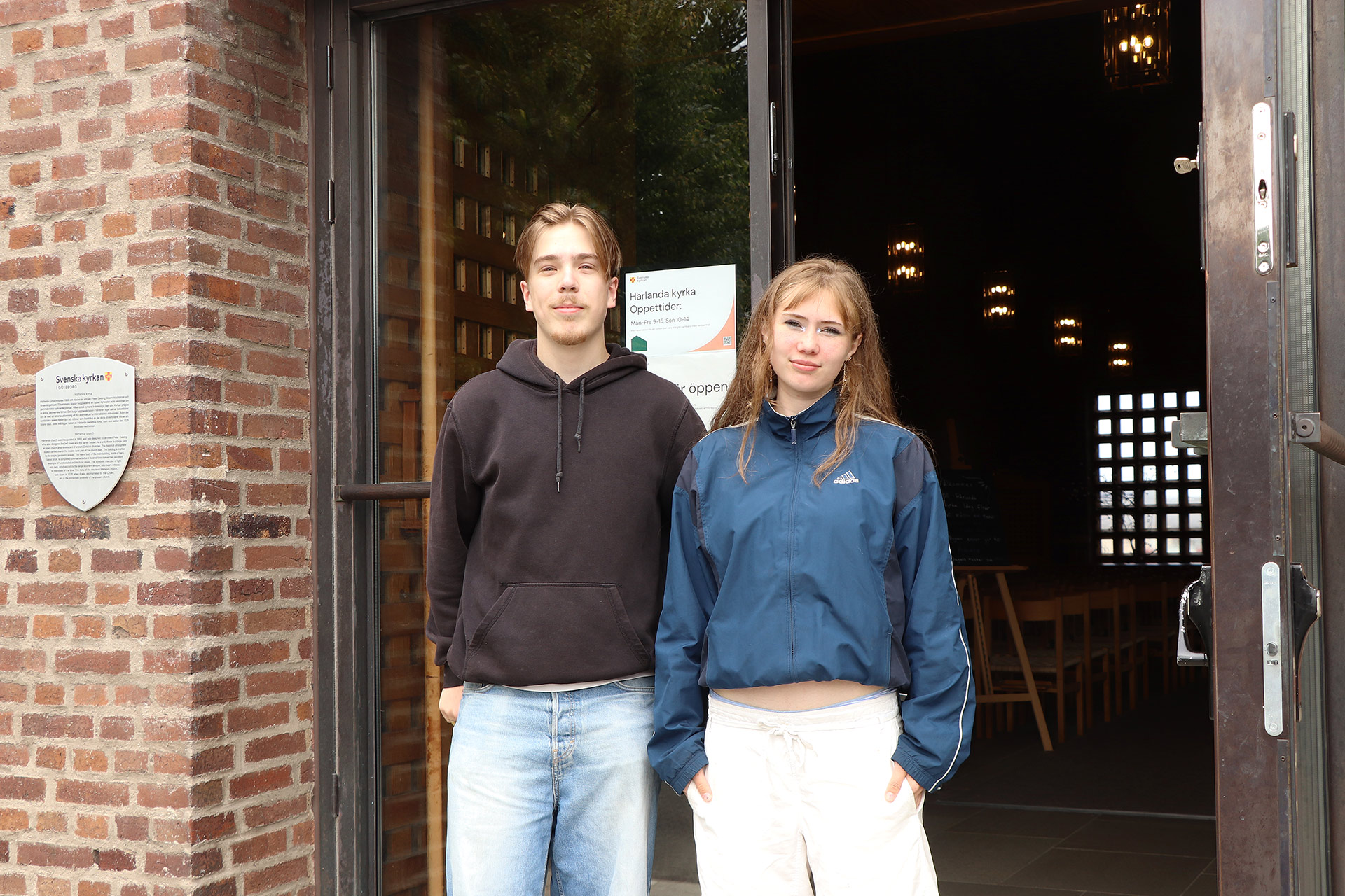 Två personer som står vid en kyrkport.