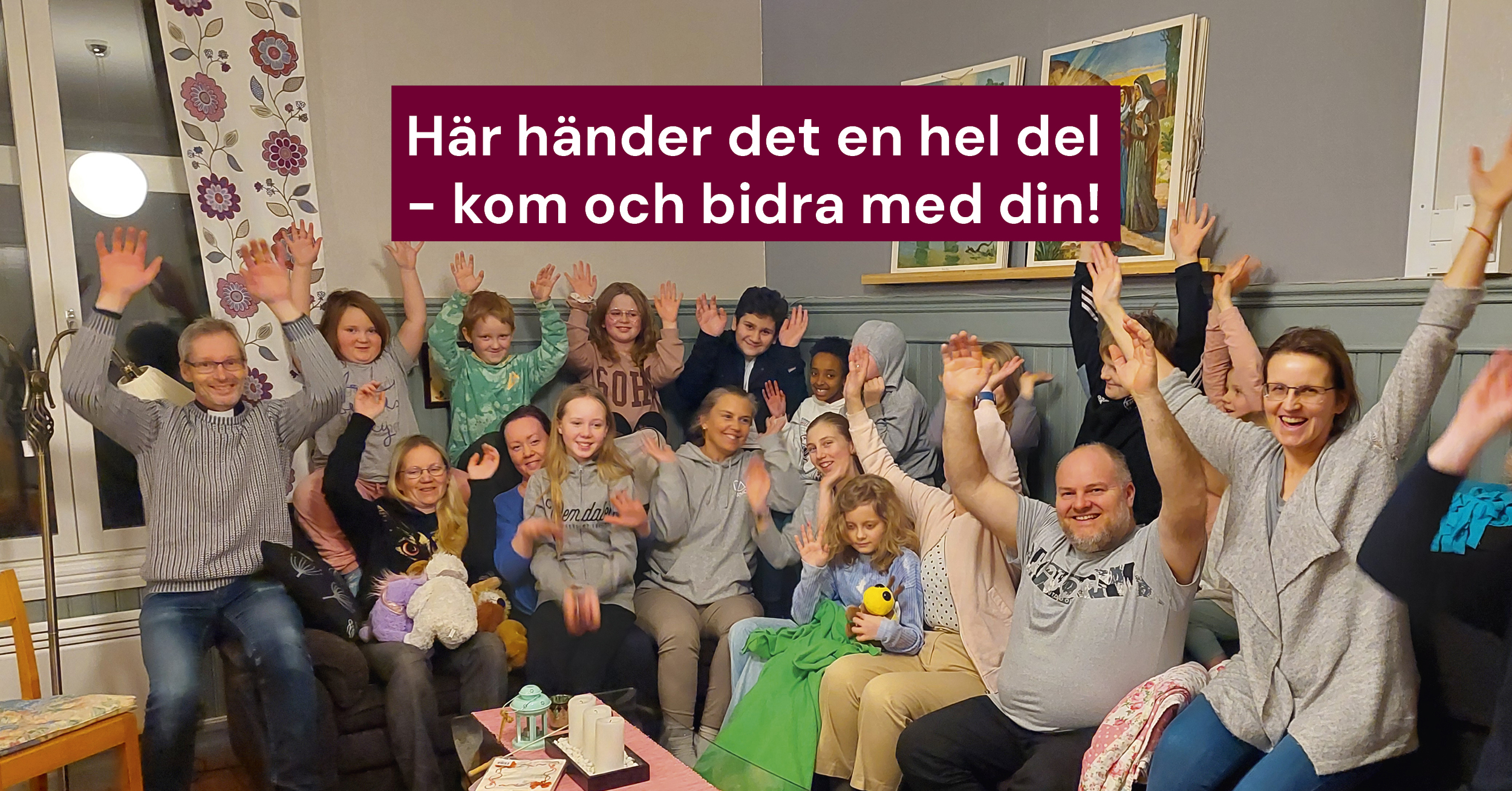 Ett gäng glada vuxna och barn med händerna i luften