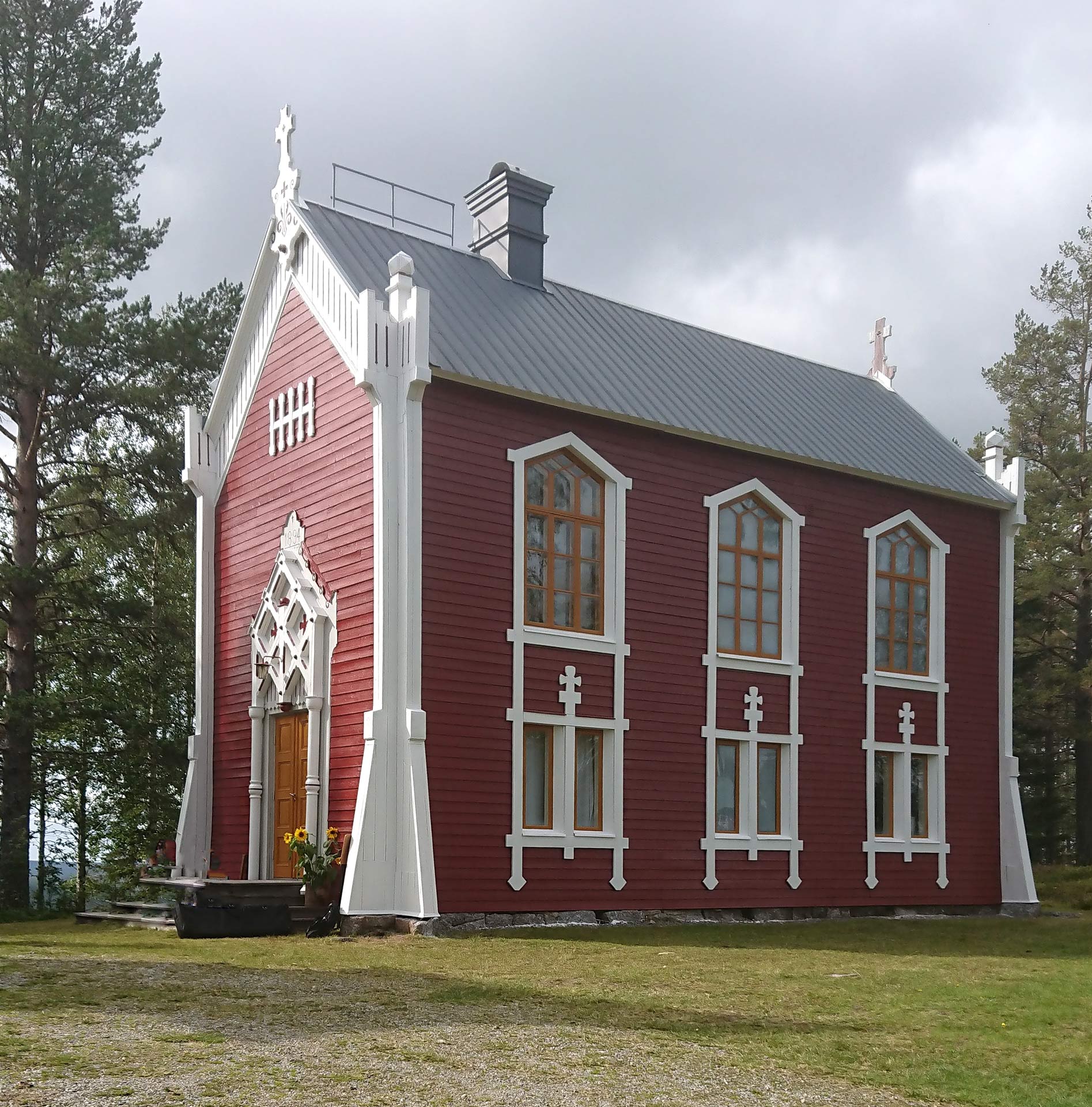 Ett skogskapell i rött trä med vita detaljer