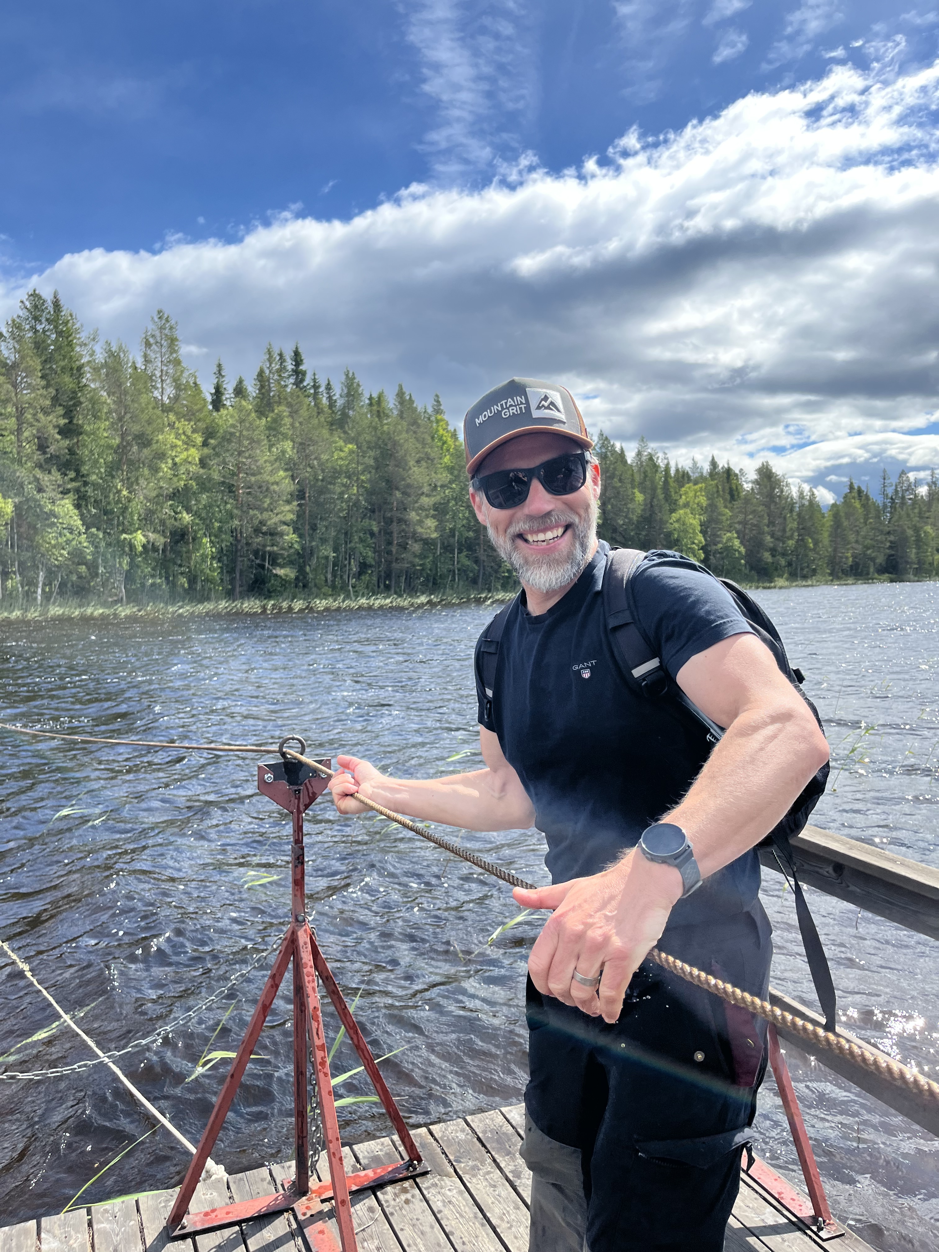 En man drar sig över en sjö på en flotte.