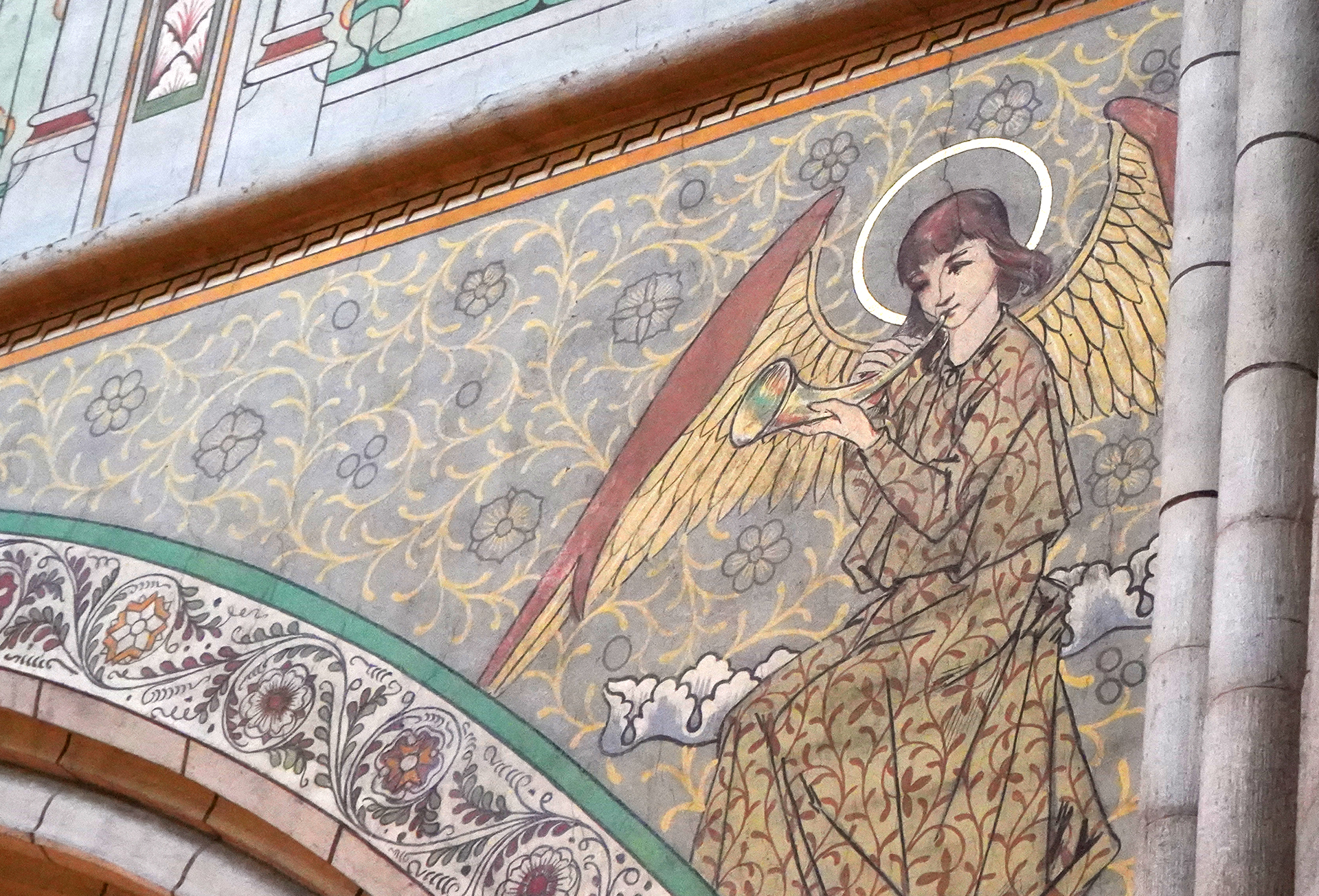 En av de musicerande änglarna över domkyrkans valvbågar, med gloria, vida vingar och ett horn som hen blåser i.