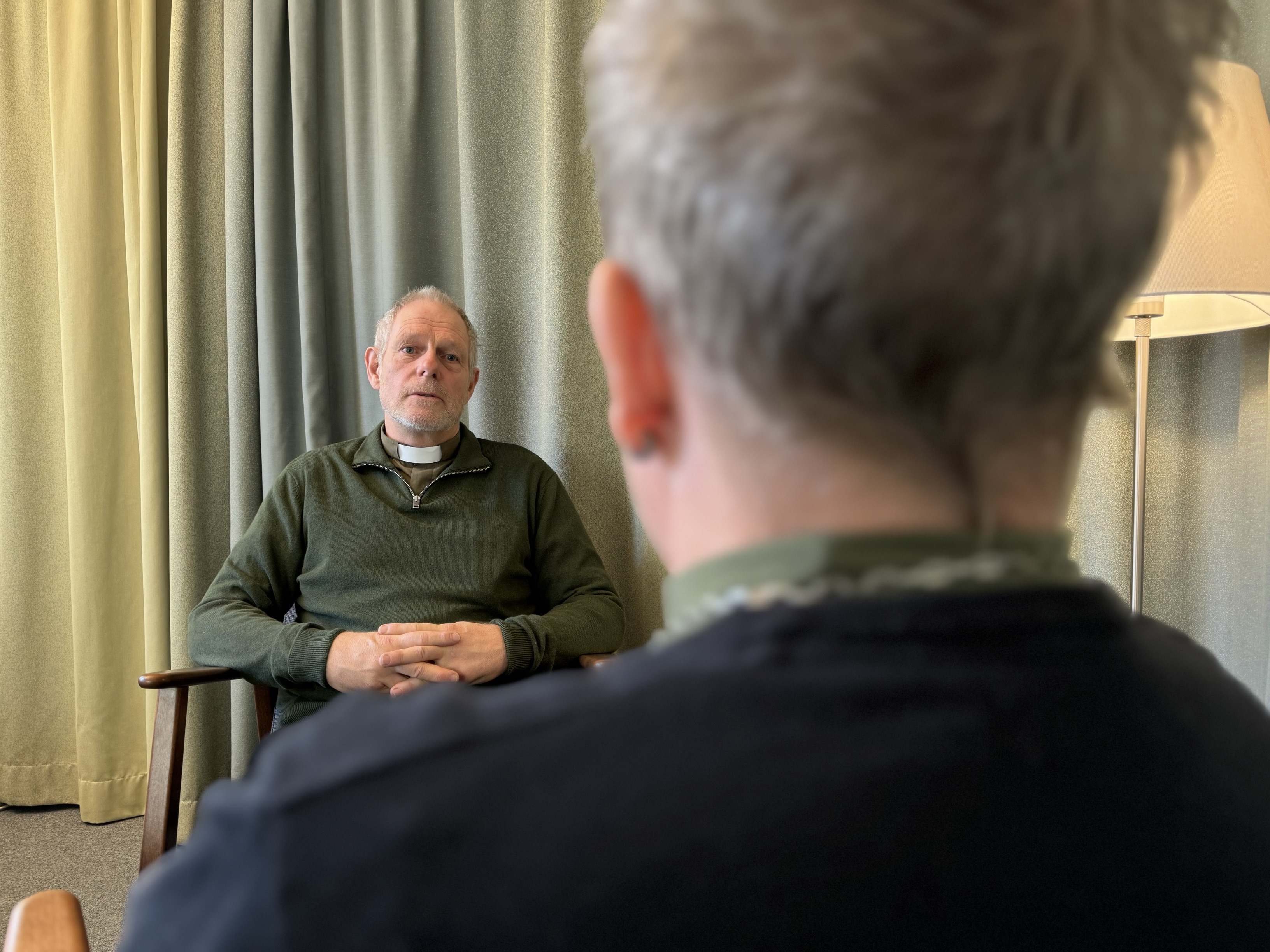 Två personer sitter och samtala i ett rum