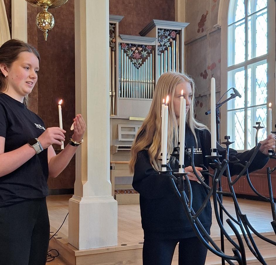 Ungdomar tänder ljus i kyrkan