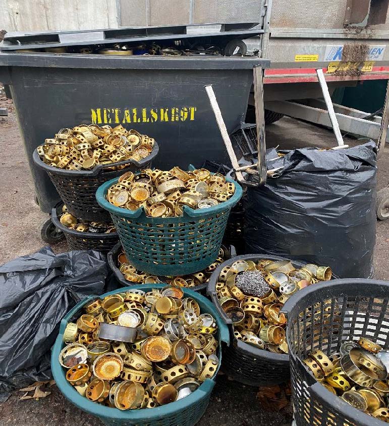Efter Allhelgonahelgen skiljer kyrkogårdens medarbetare metallocket från stearinkoppen på utbrunna gravljus, för att kunna återvinna plast och metall separat. En hel 10m3 container med gravljus-plast blir det som kan återvinnas! Metallocken ligger 4 stycken lövkorgar på bilden.