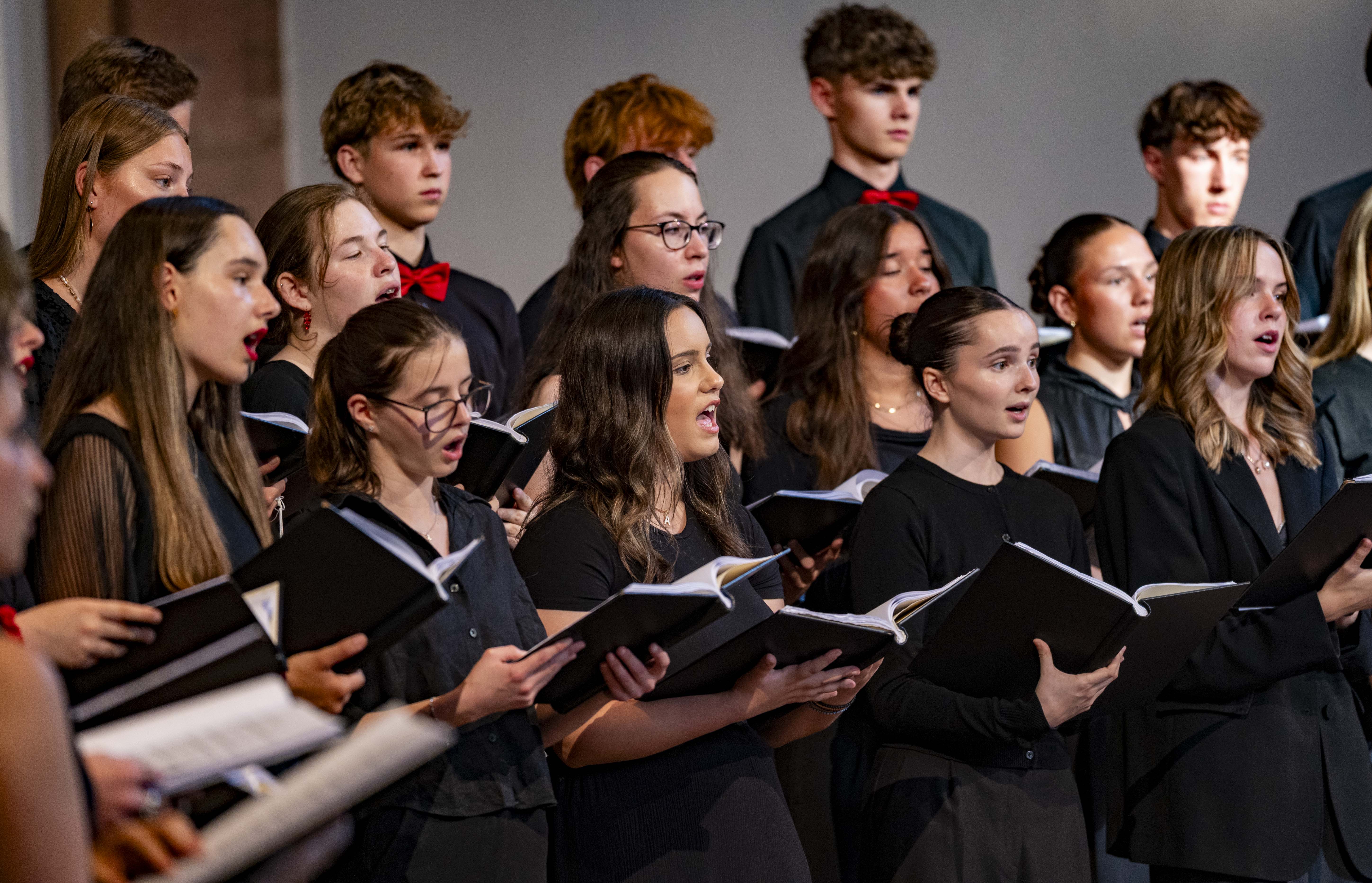 En sjungande ungdomskör i svarta kläder