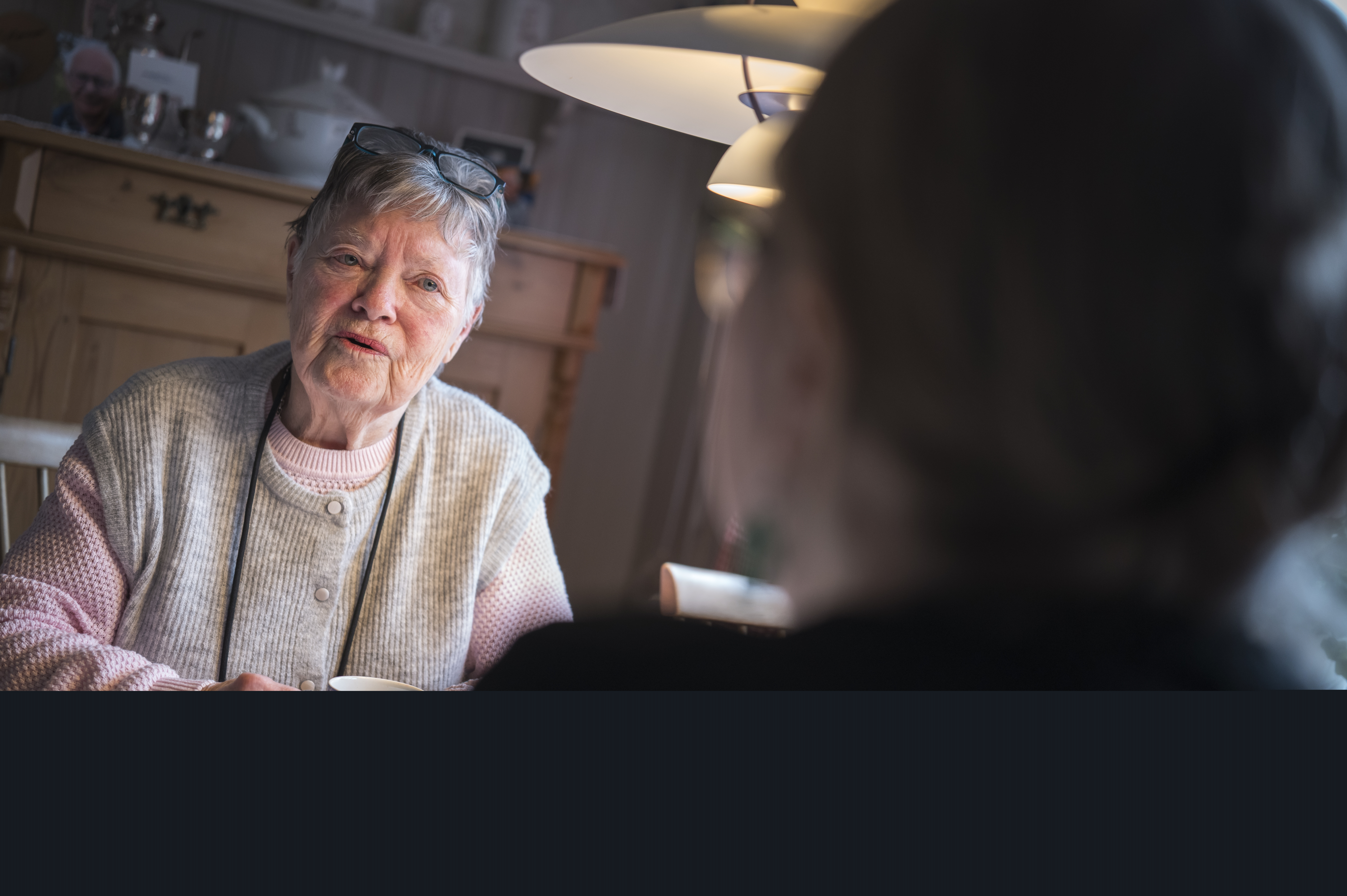 Två personer sitter och samtalar över en kopp kaffe