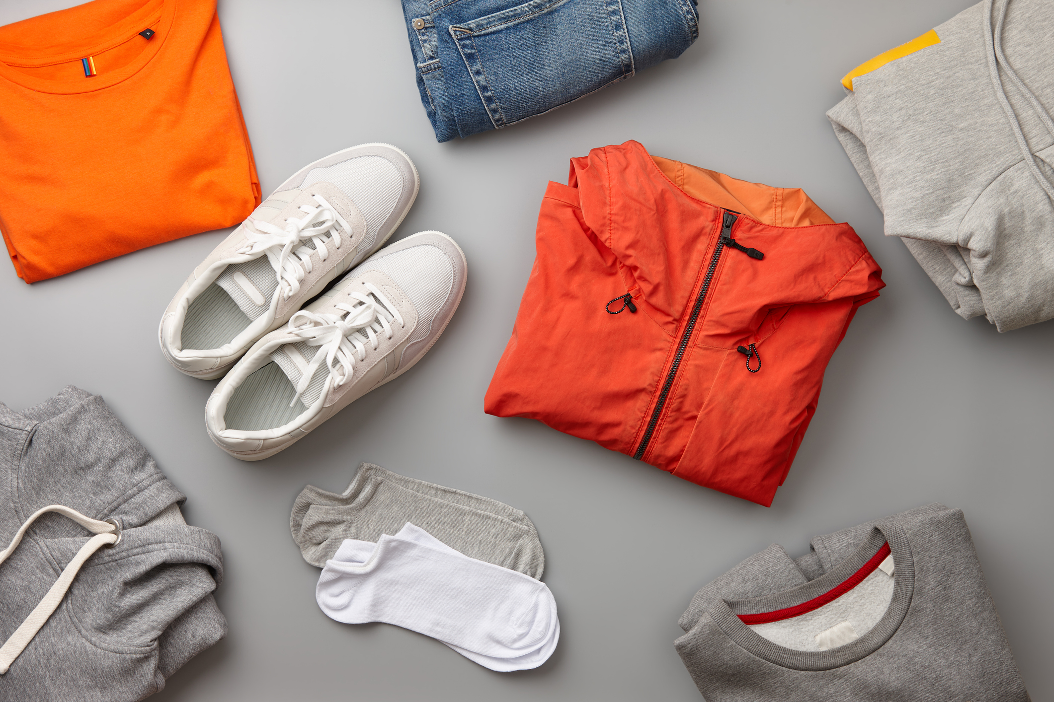 Vår och sommarkläder upplagda på en grå bakgrund