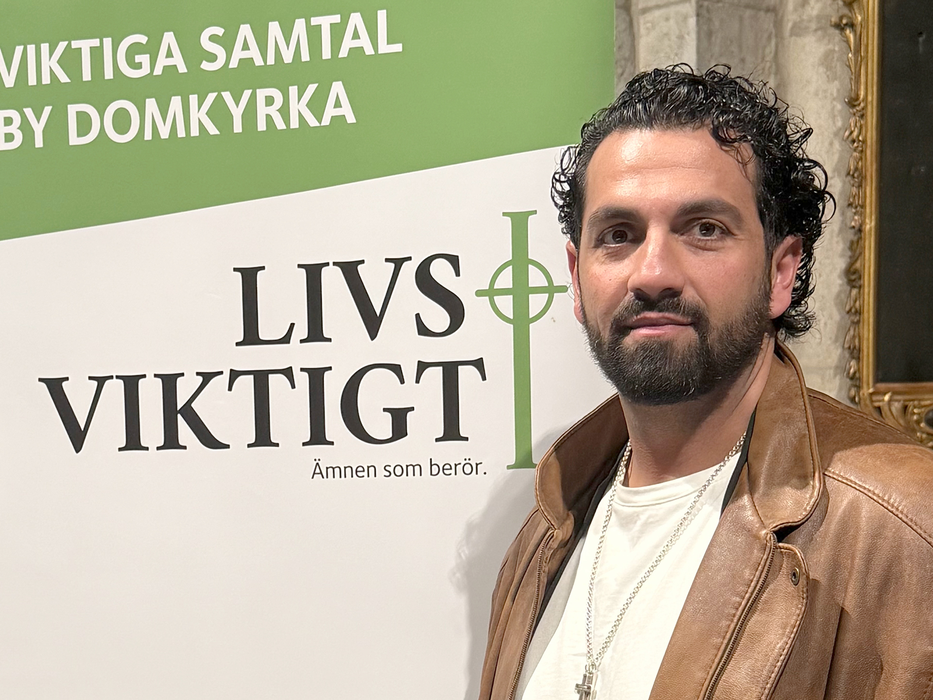 Nadim Ghazale står framför en rollup med Livsviktigts logotyp
