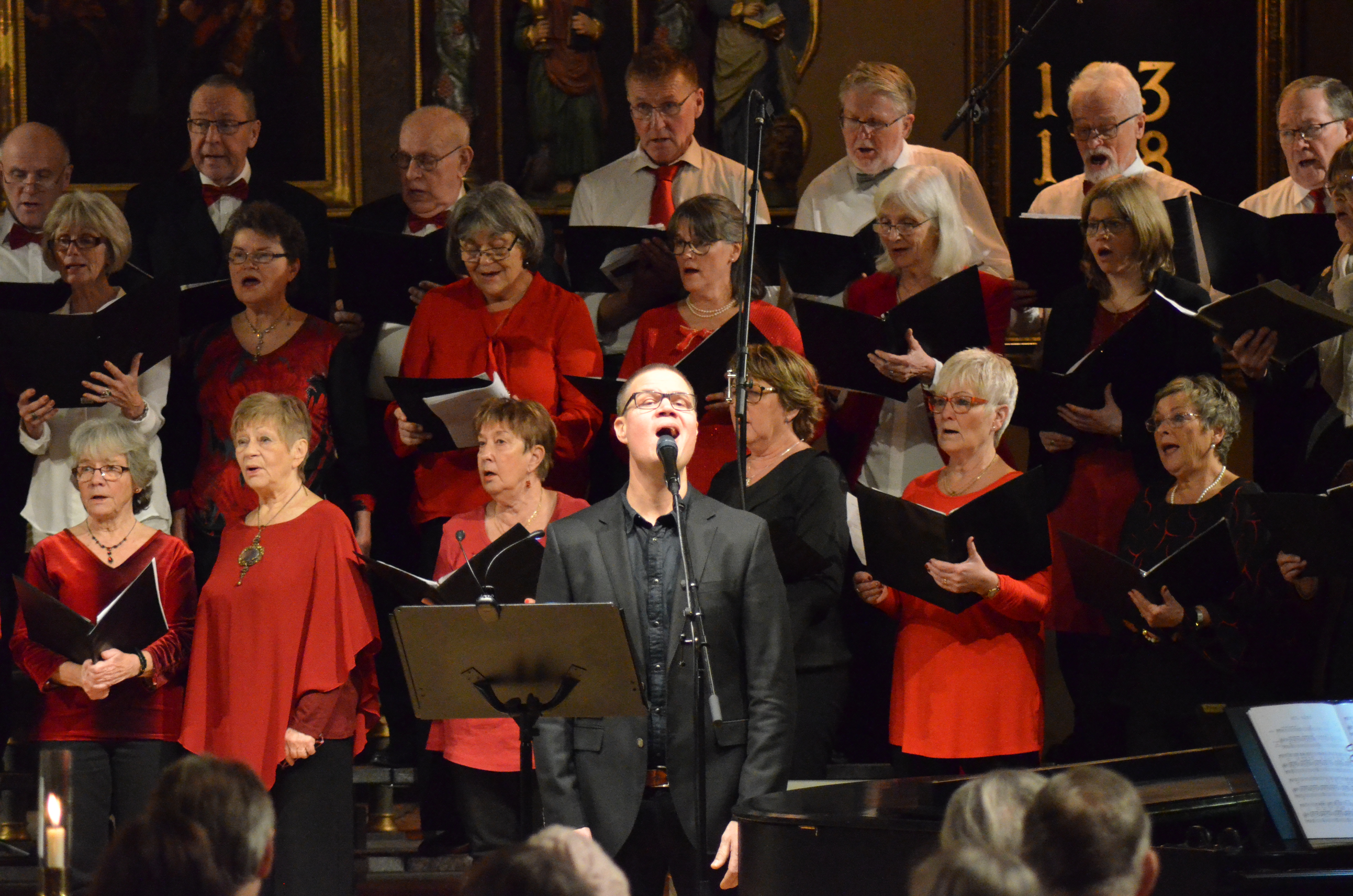 Bild på kör i röda, vita, svarta kläder