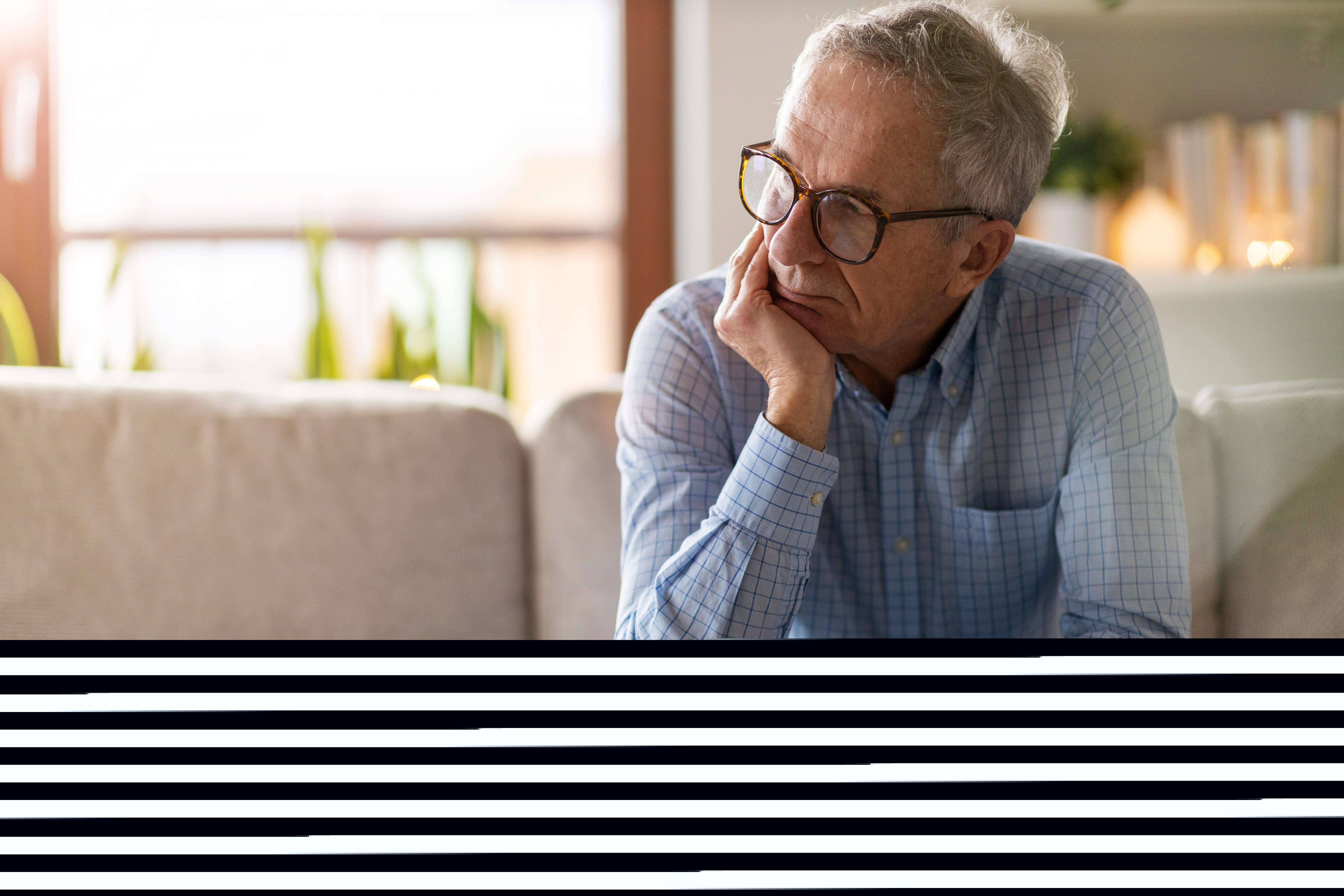 Man sitter på en soffkant och ser sorgsen ut, försjunken i tankar