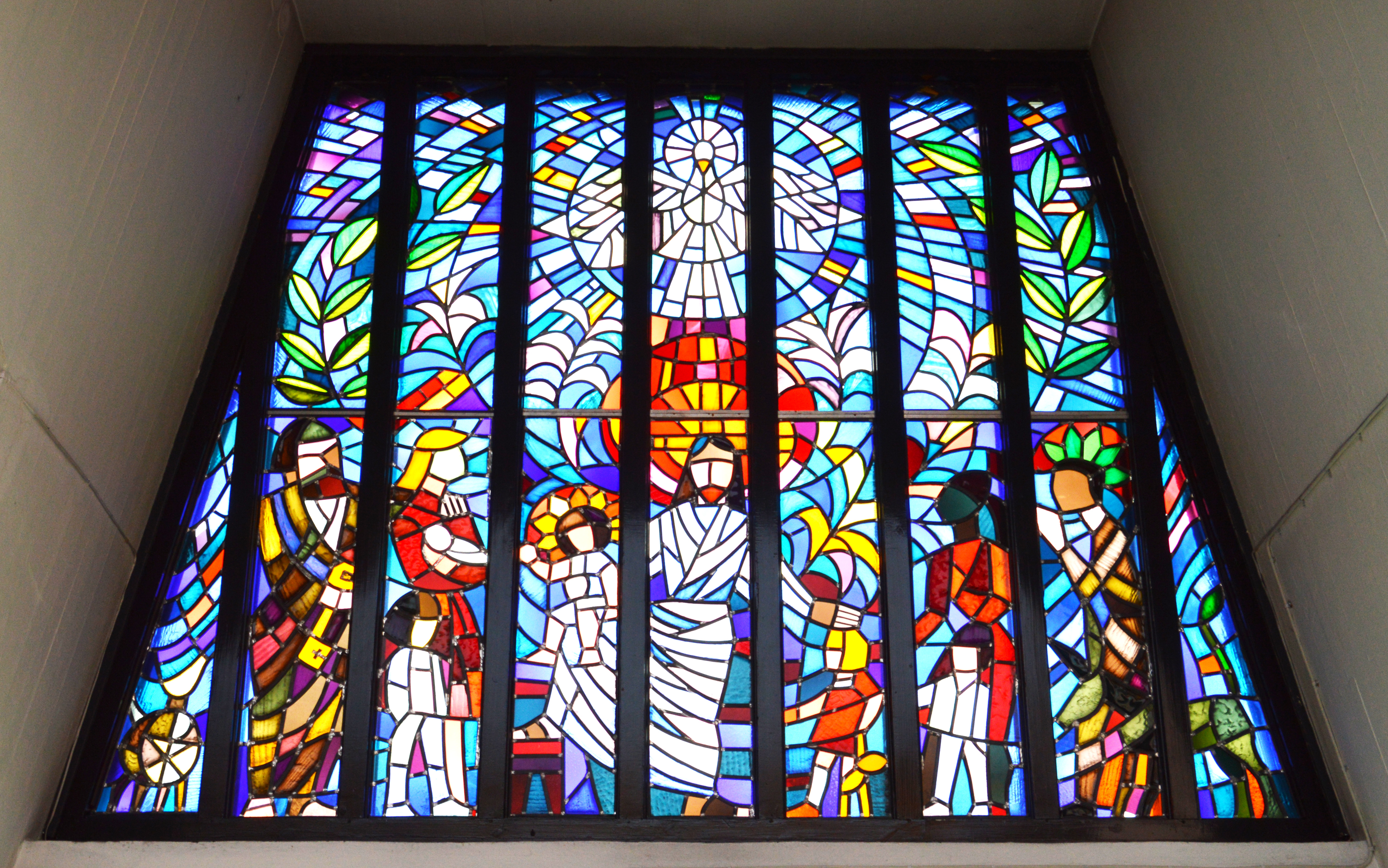 Det färgglada fönstret i Petersgårdens kyrka. Här är evangeliet om Jesus och barnet illustrerat. 