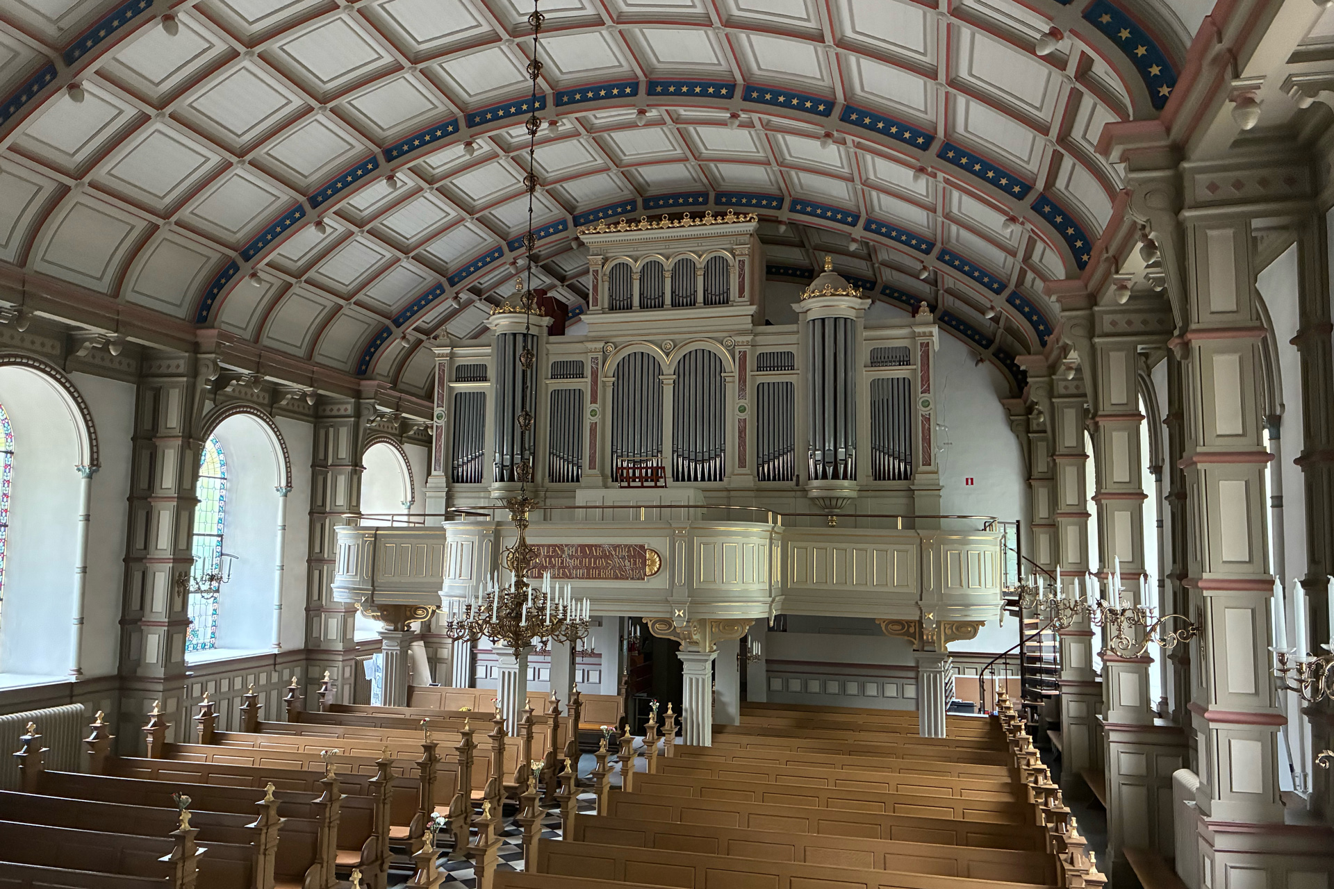 Den stora läktarorgeln vilar på fyra kolonner precis när man kommer in i kyrkan. Den tronar upp sig under det välvda kyrktaket.