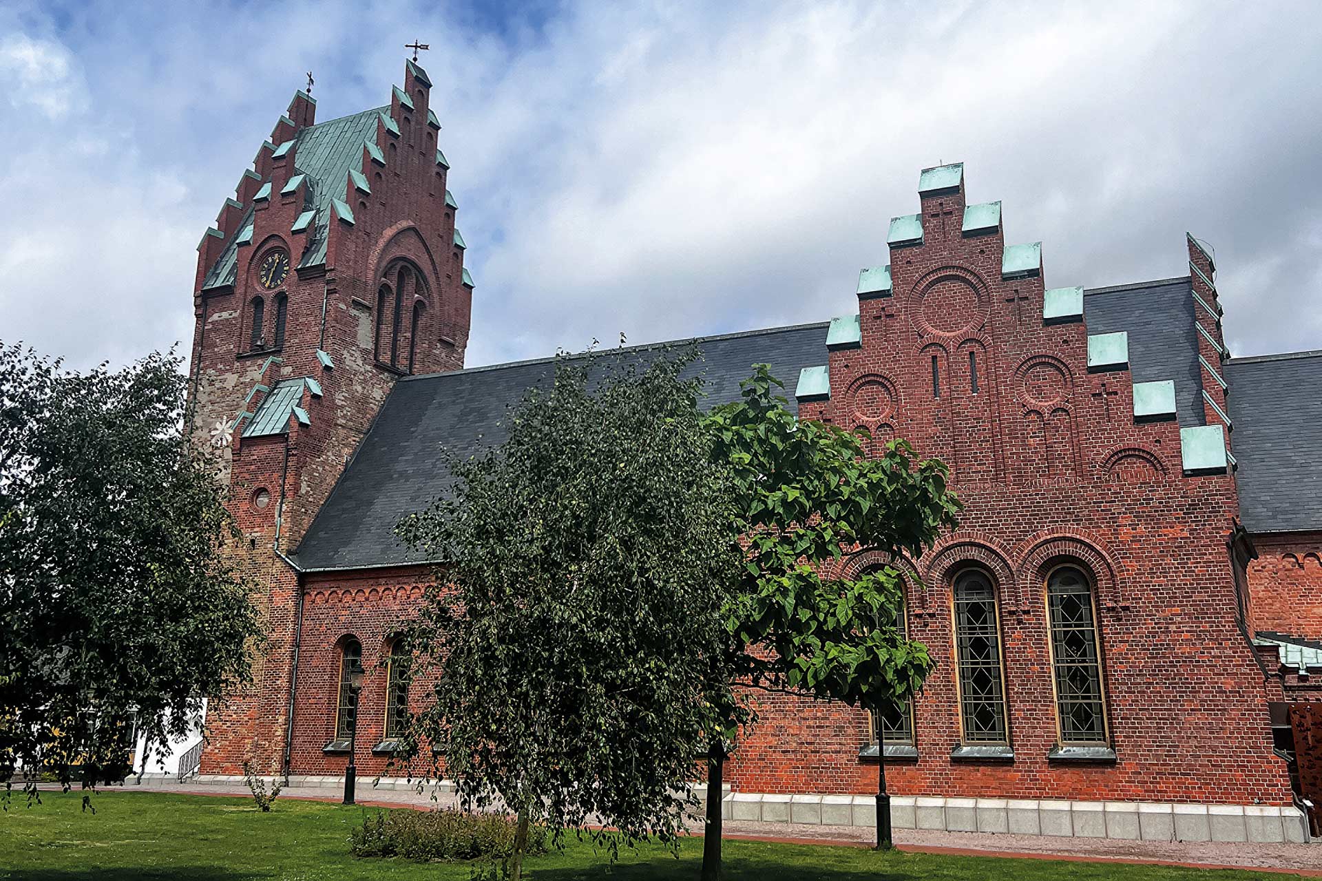 Röd tegelkyrka med torn.