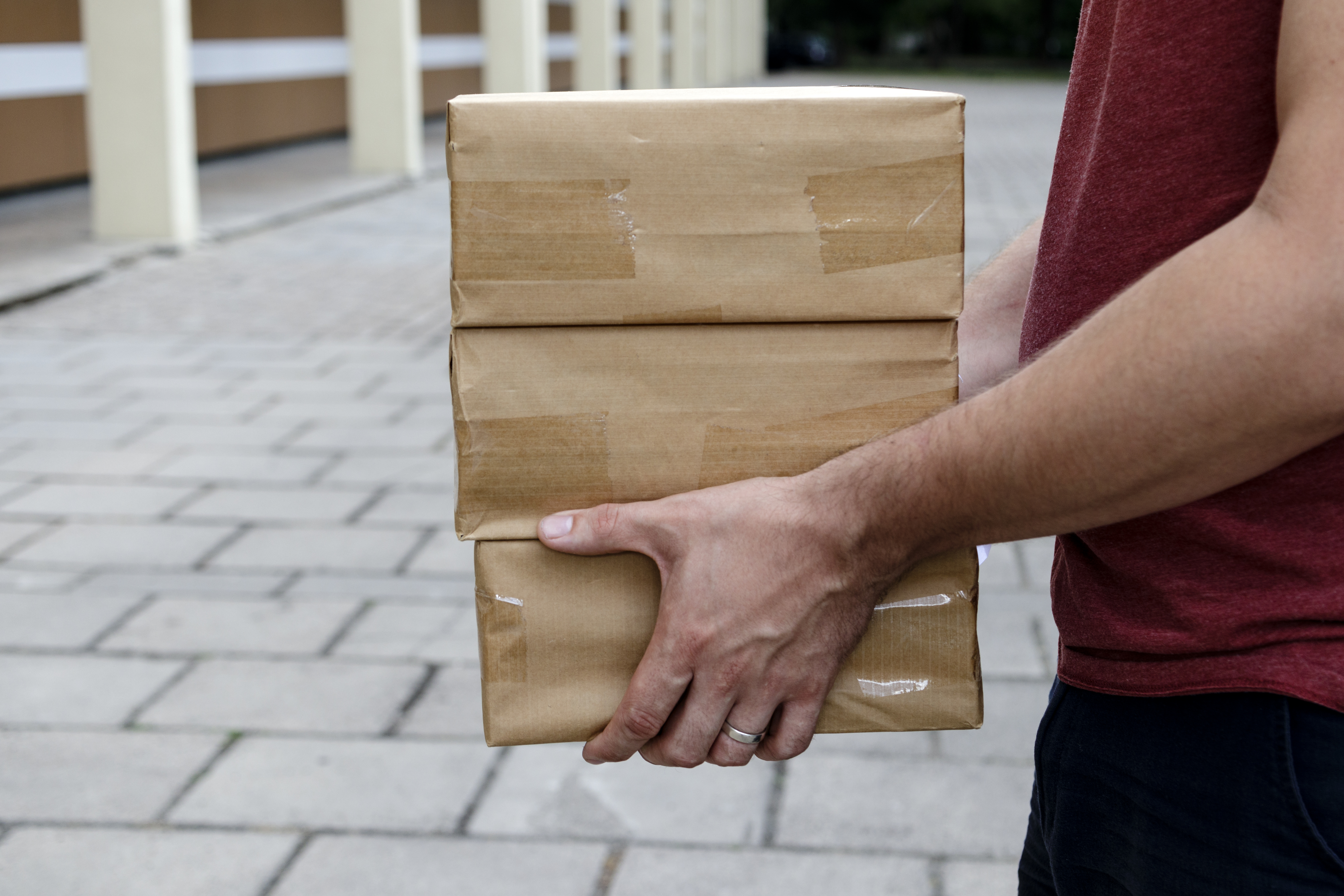 Paketleverans. Ett bud håller i förpackningar eller kartonger.