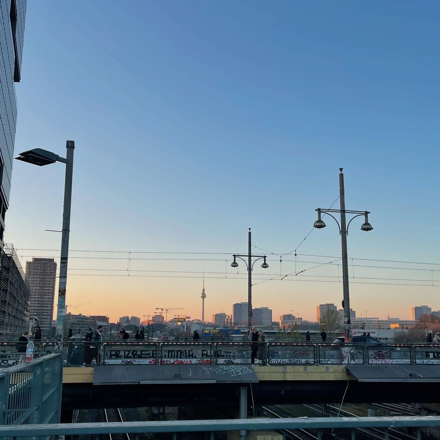 Stadsbild över Berlin, med höghus, torn och en järnvägsbro.