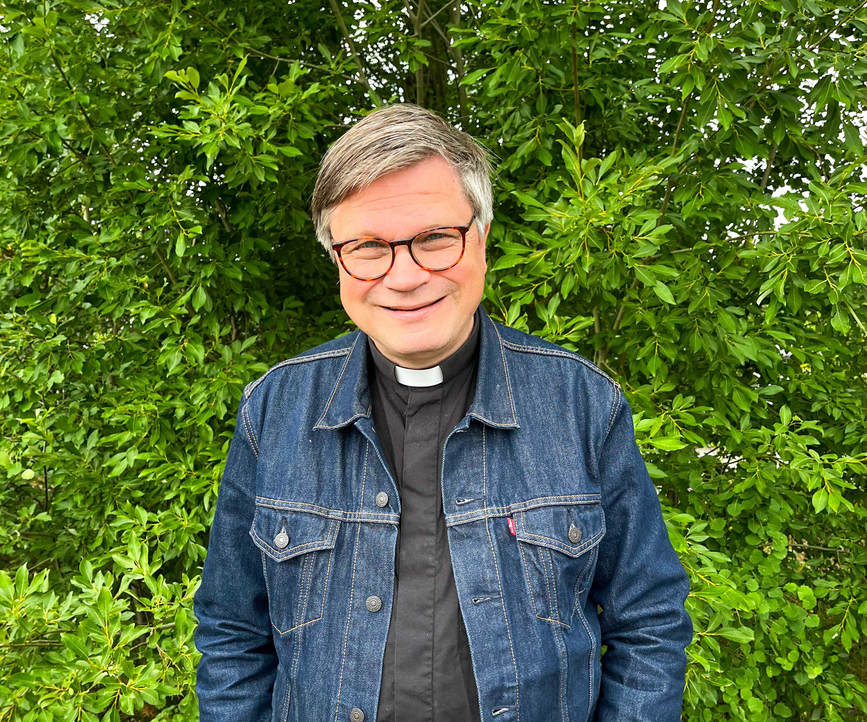 Jan står framför ett buskage.
