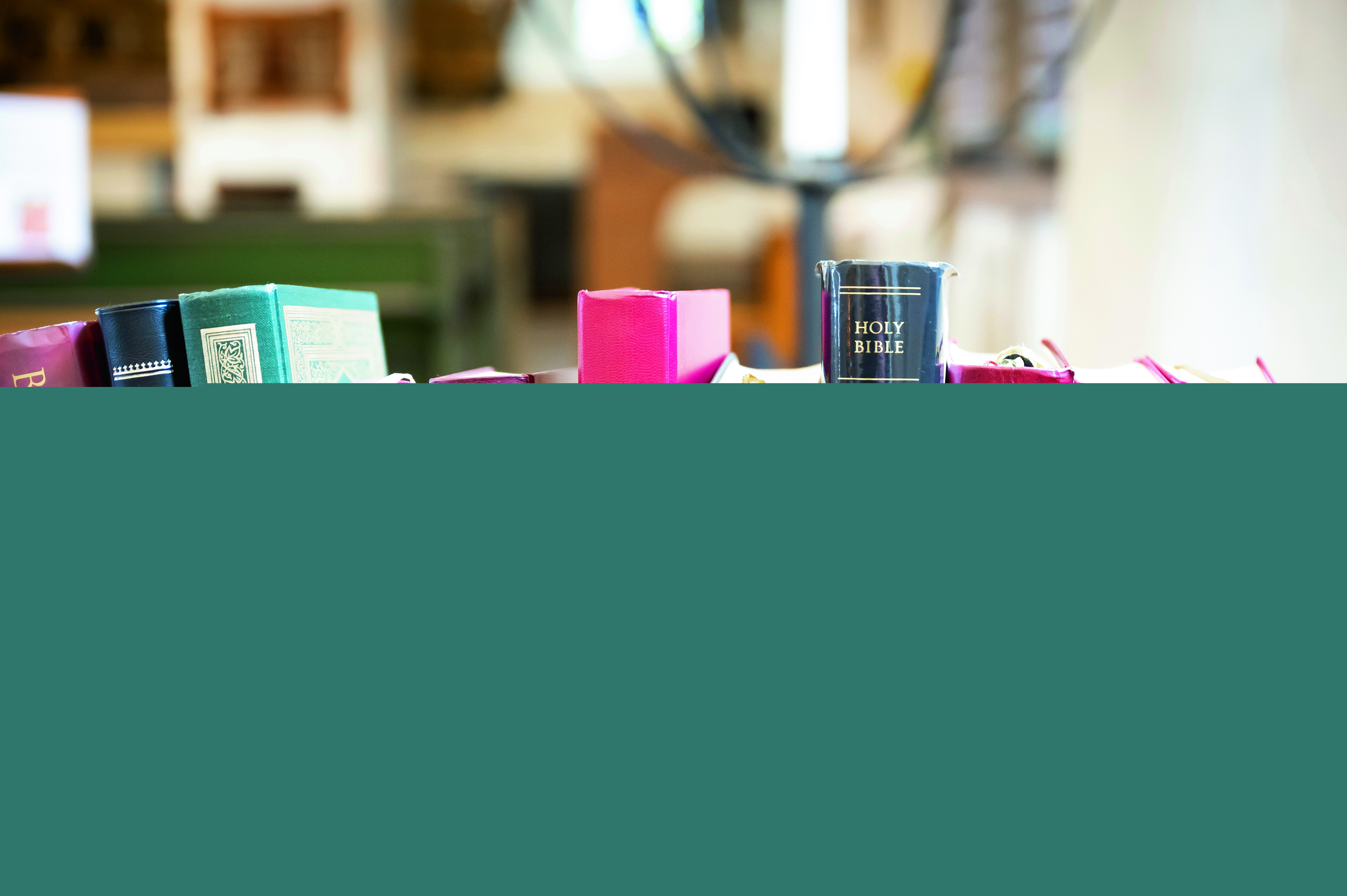 En rad biblar på olika språk som står i en hylla