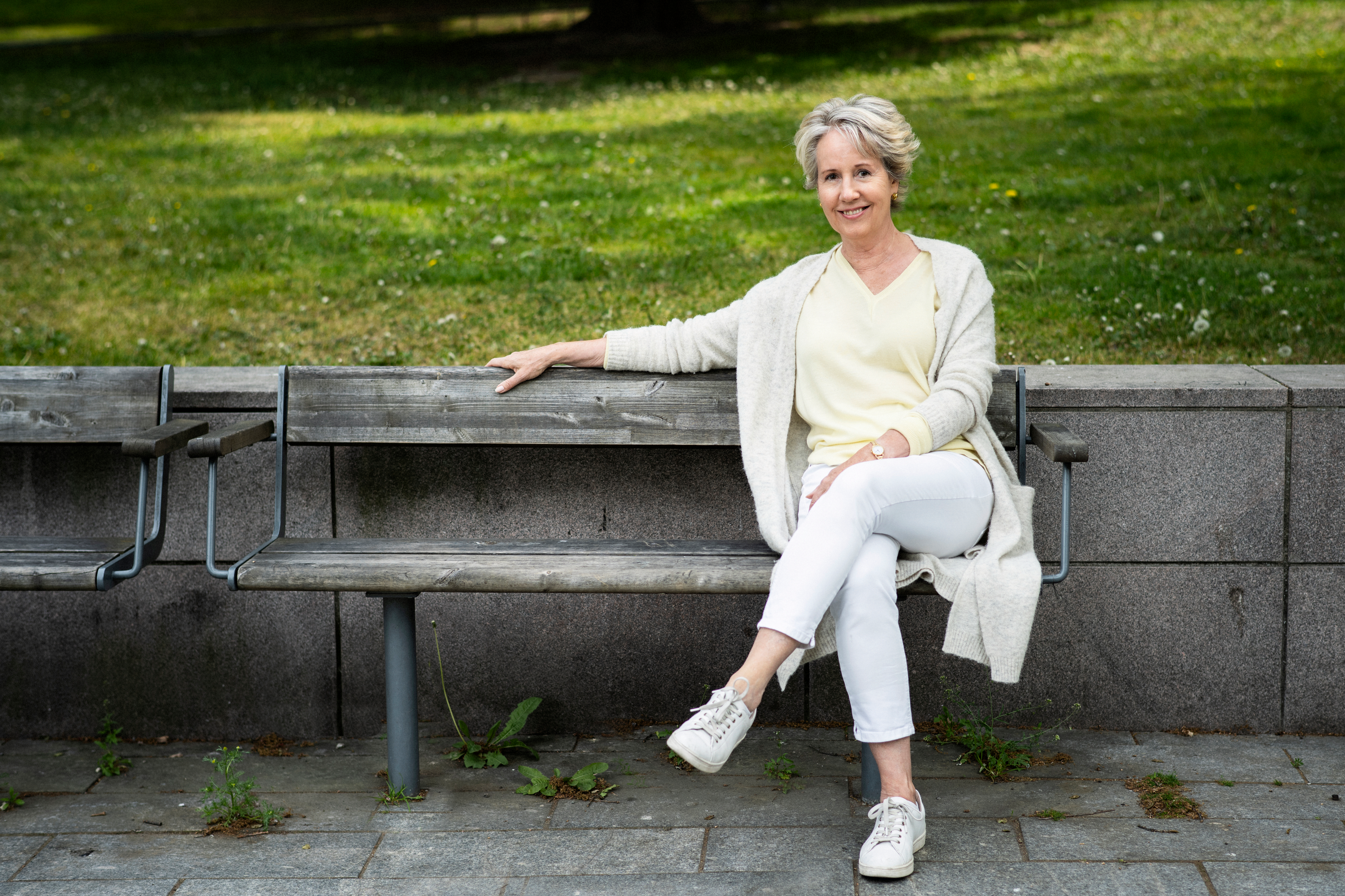 Författaren Åsa Kruse sitter på en parkbänk.