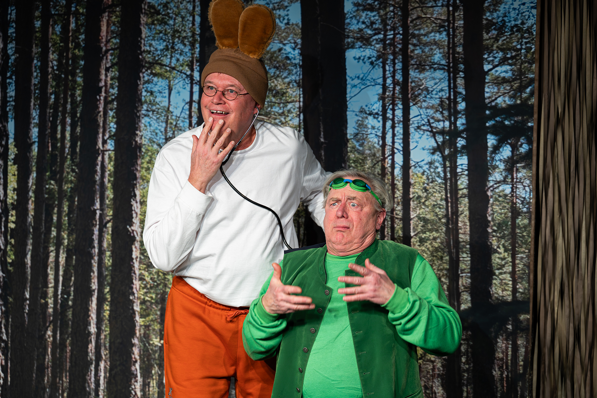 Två skådespelare är utklädda till en hare och en groda. I bakgrunden är det en kuliss med skog.