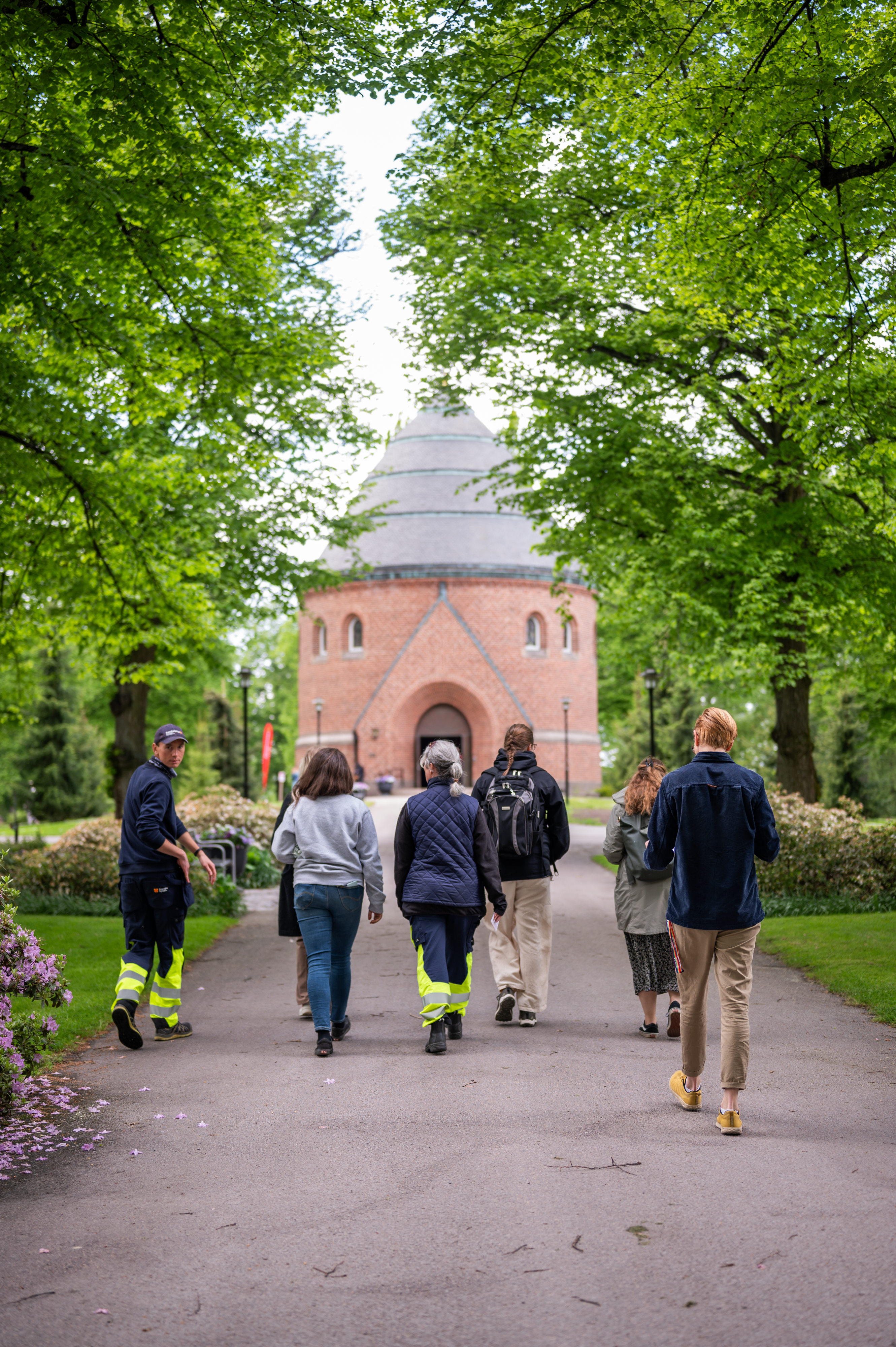 Medarbetare från Norrköpings pastorat går i en park, sedda bakifrån