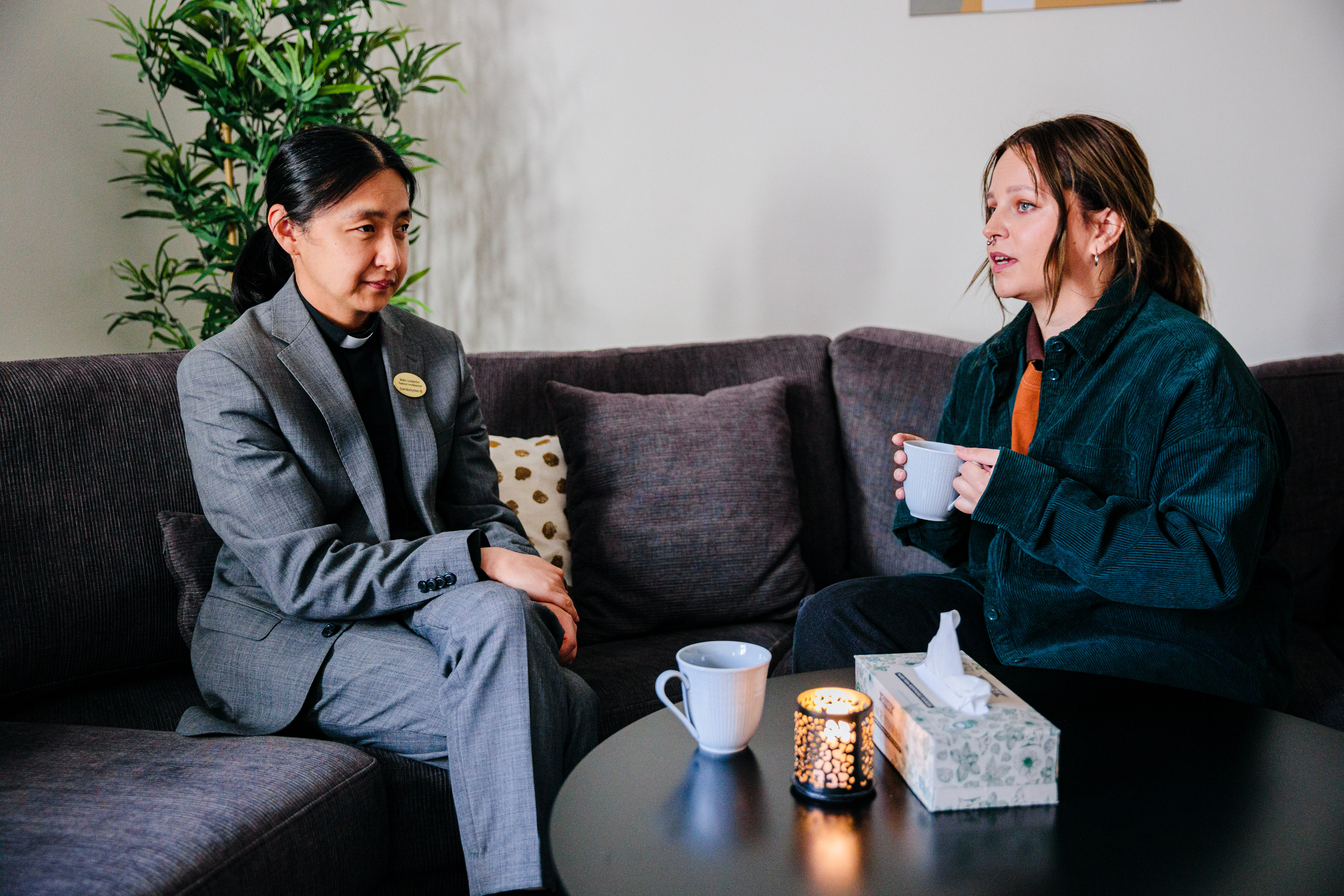 Präst och kvinna i samtal i en soffa