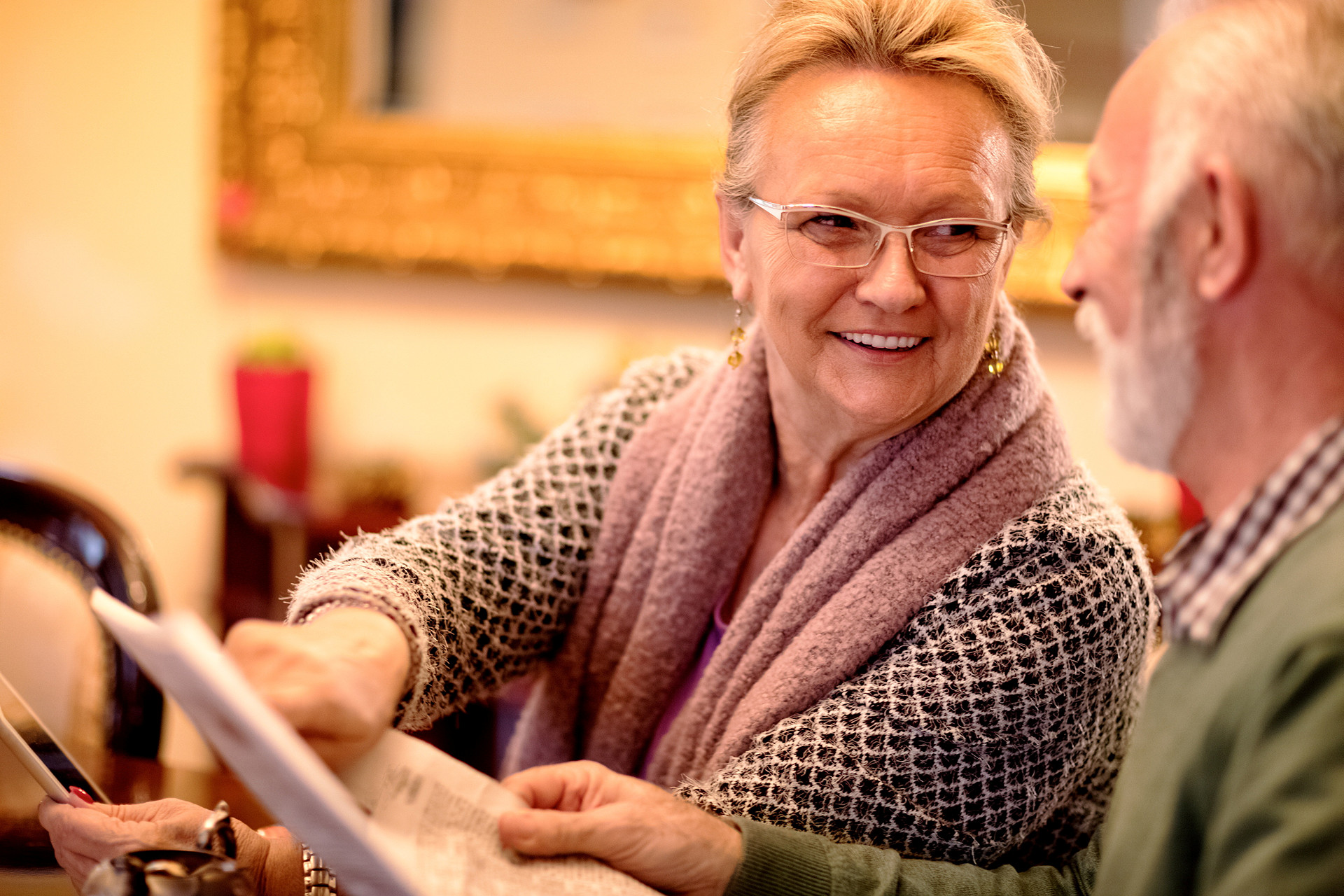 Ett glatt äldre par diskuterar över en surfplatta.