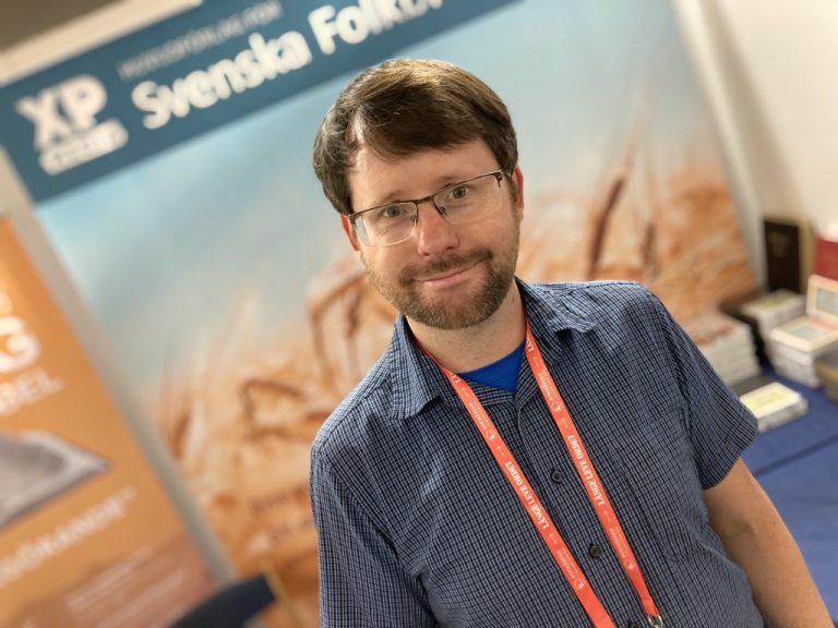Tony Larsdal står framför Svenska folkbibelns monter på bokmässan.
