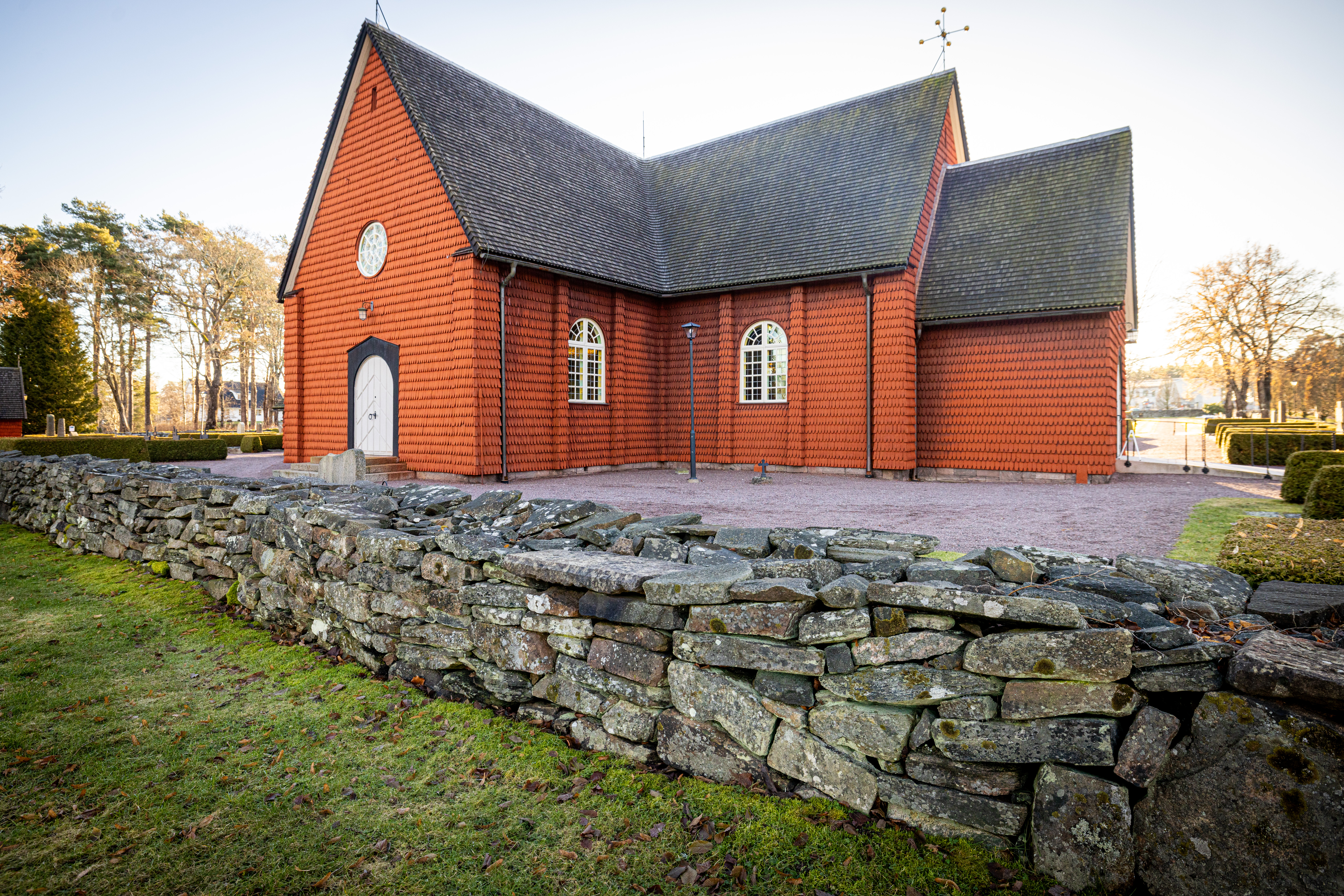 Hammarö kyrka med stenmuren i förgrunden