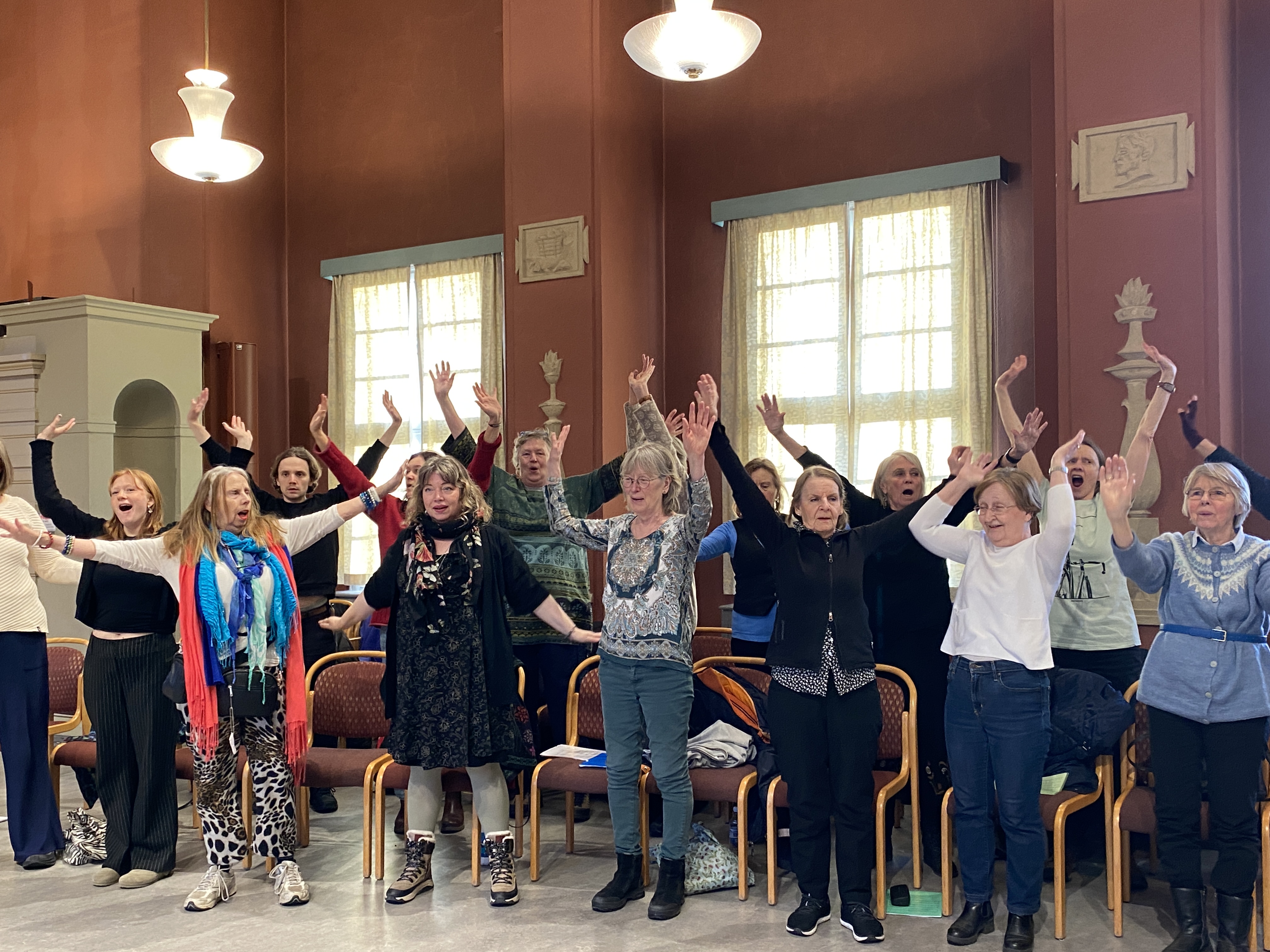 En grupp personer sträcker upp armarna i luften 