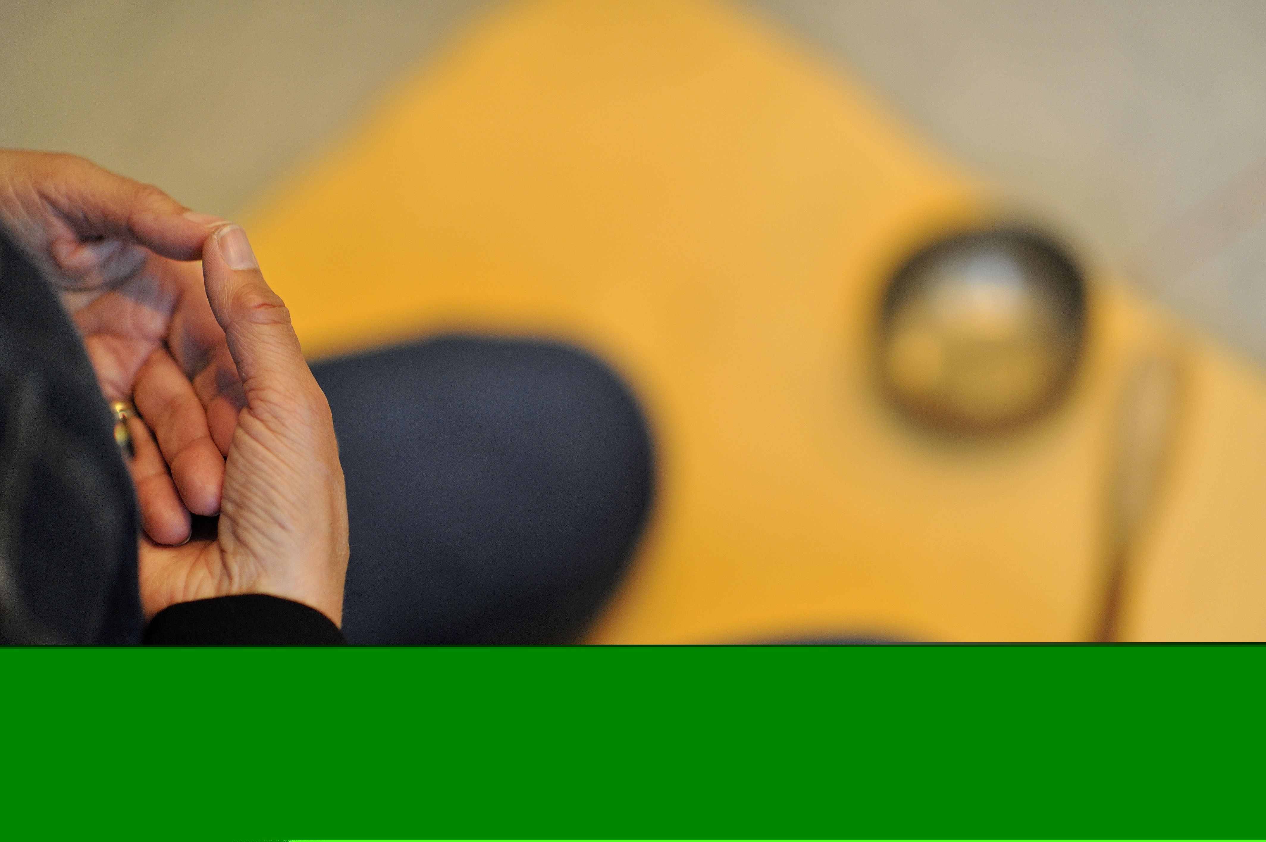 Kvinna sitter och mediterar på gul yogamatta.