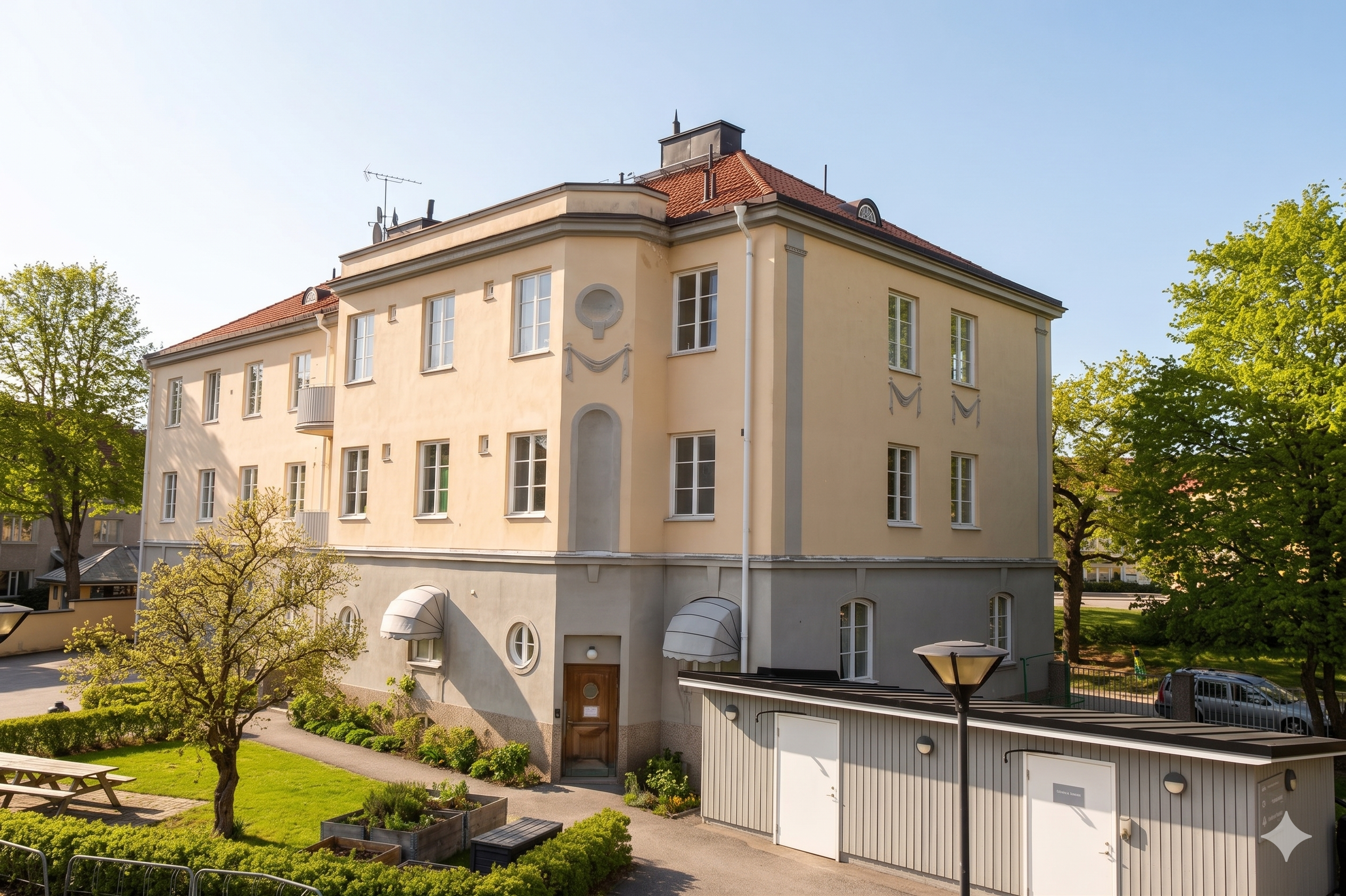 Exteriören av Olaus Petri prästgård, gult sekelskifteshus, grön innergård med pallkragar och ett soprum