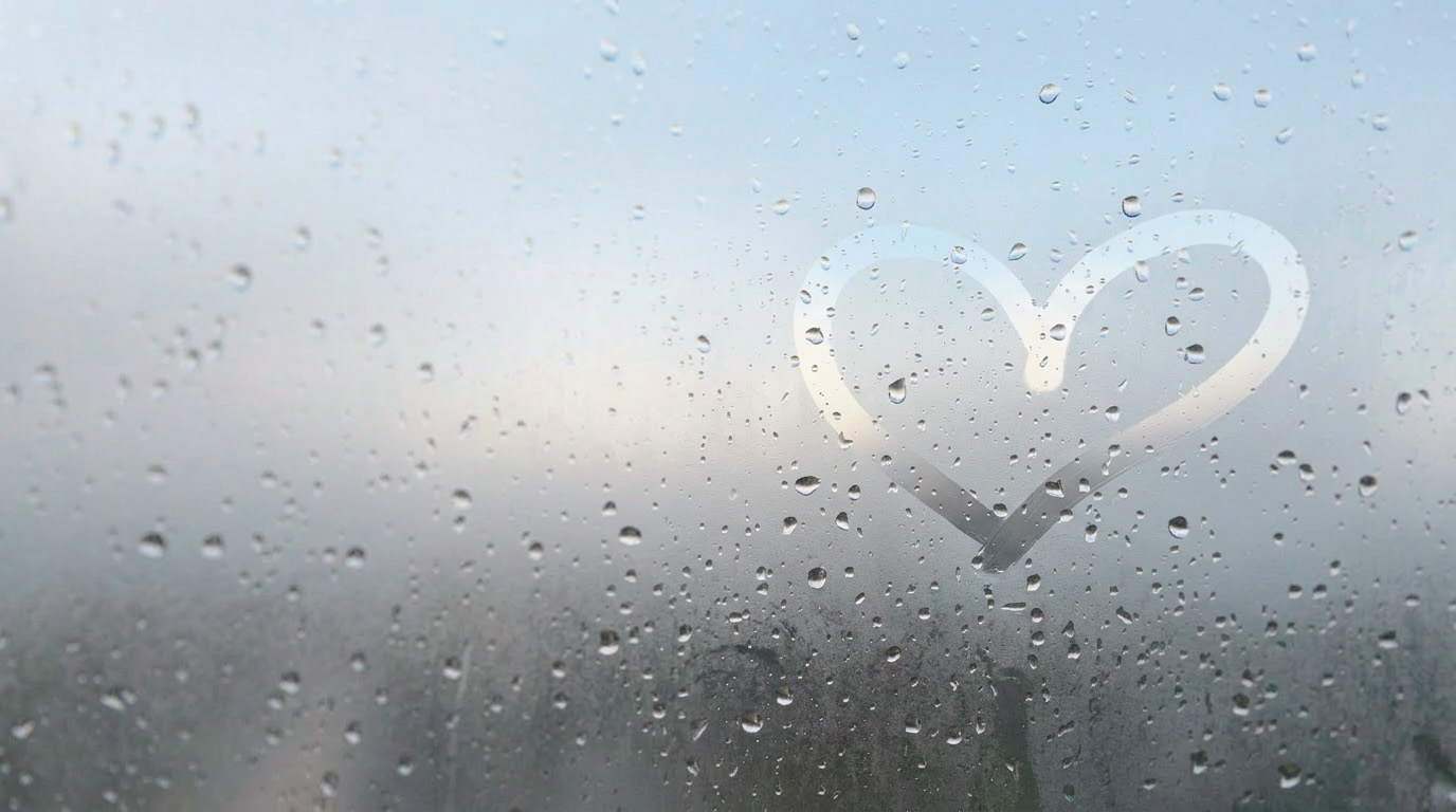 Ett hjärta ritat i imman på en fuktig glasruta.