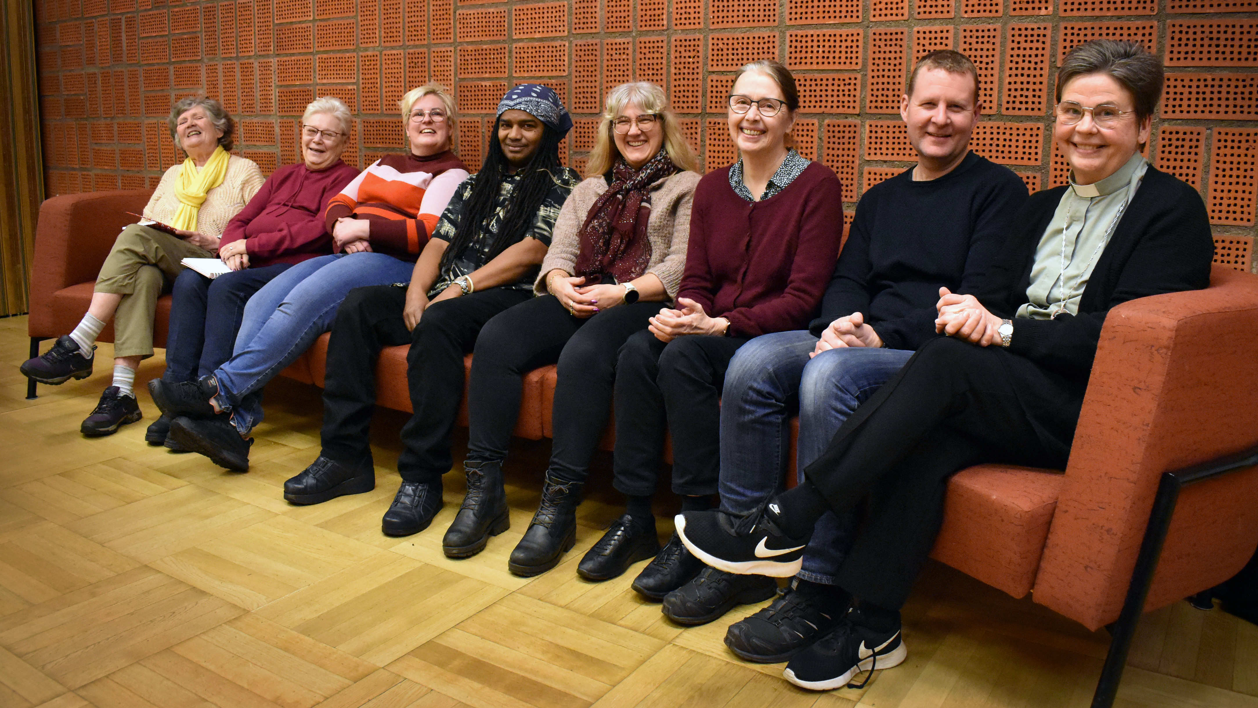 Grupp människor som sitter i en soffa.