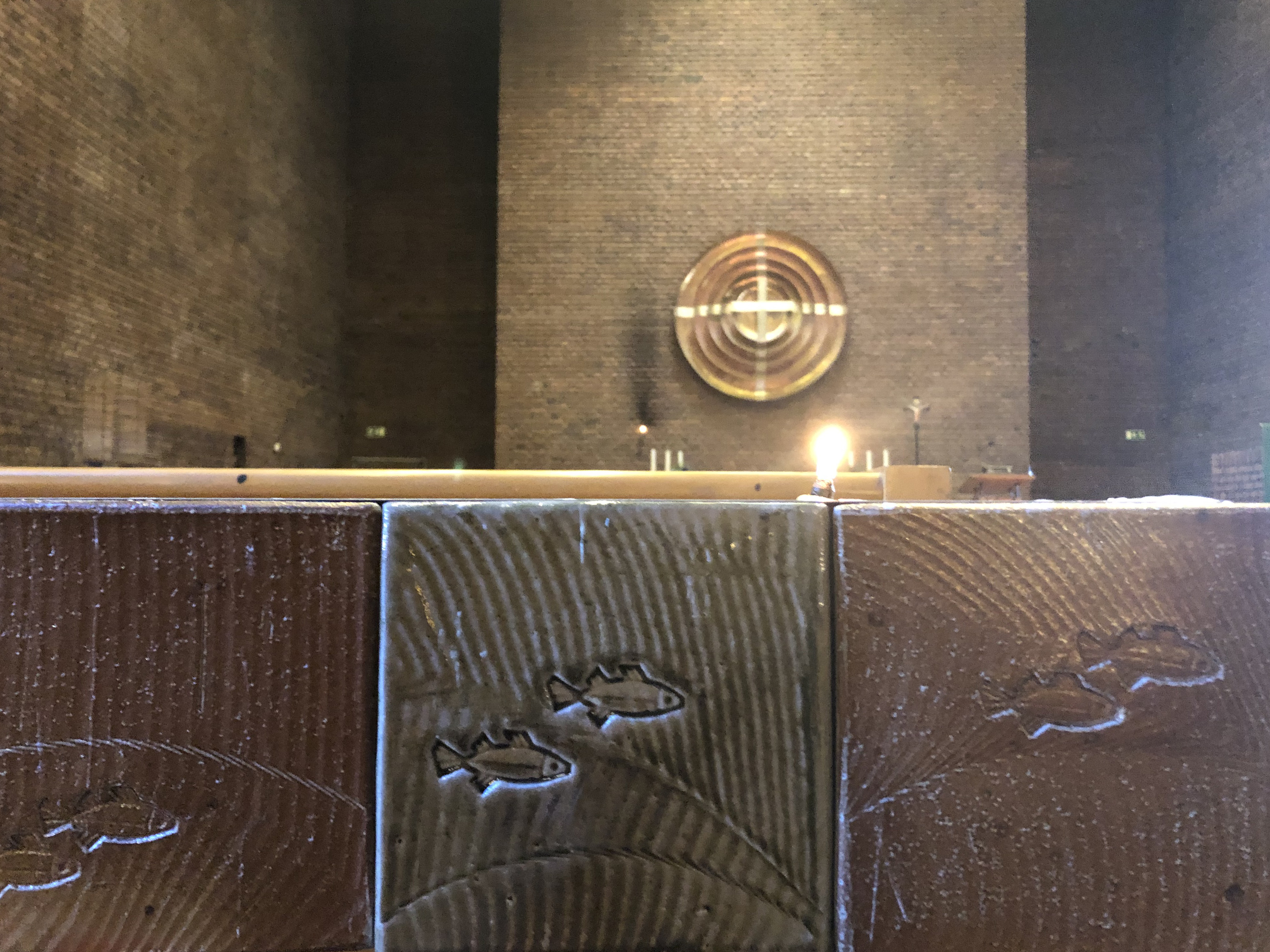 Närbild på ljusbärare med altarutsmyckning i bakgrunen