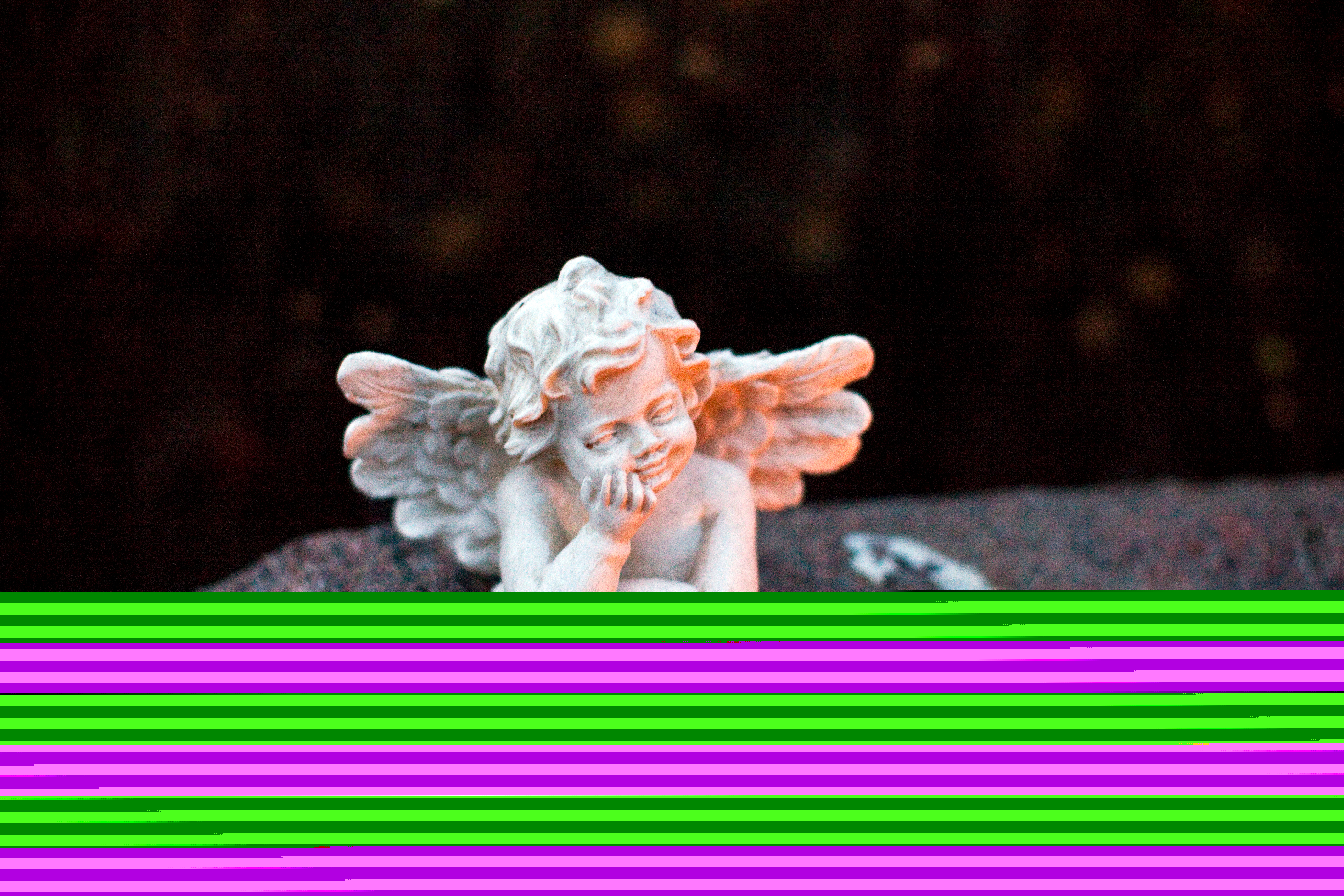 En liten vit ängel i sten ligger på en gravsten.