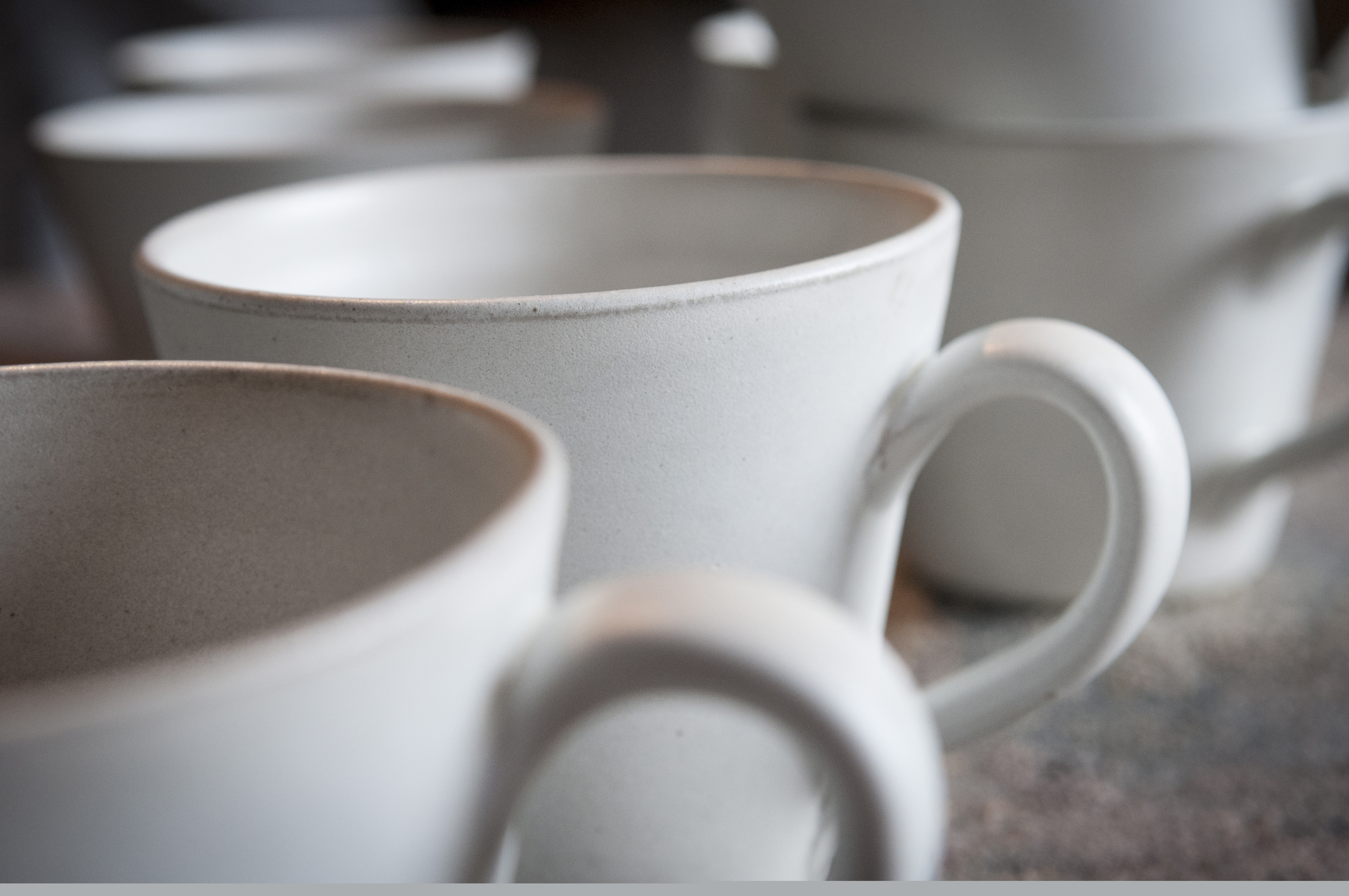 Några vita kaffemuggar i keramik.