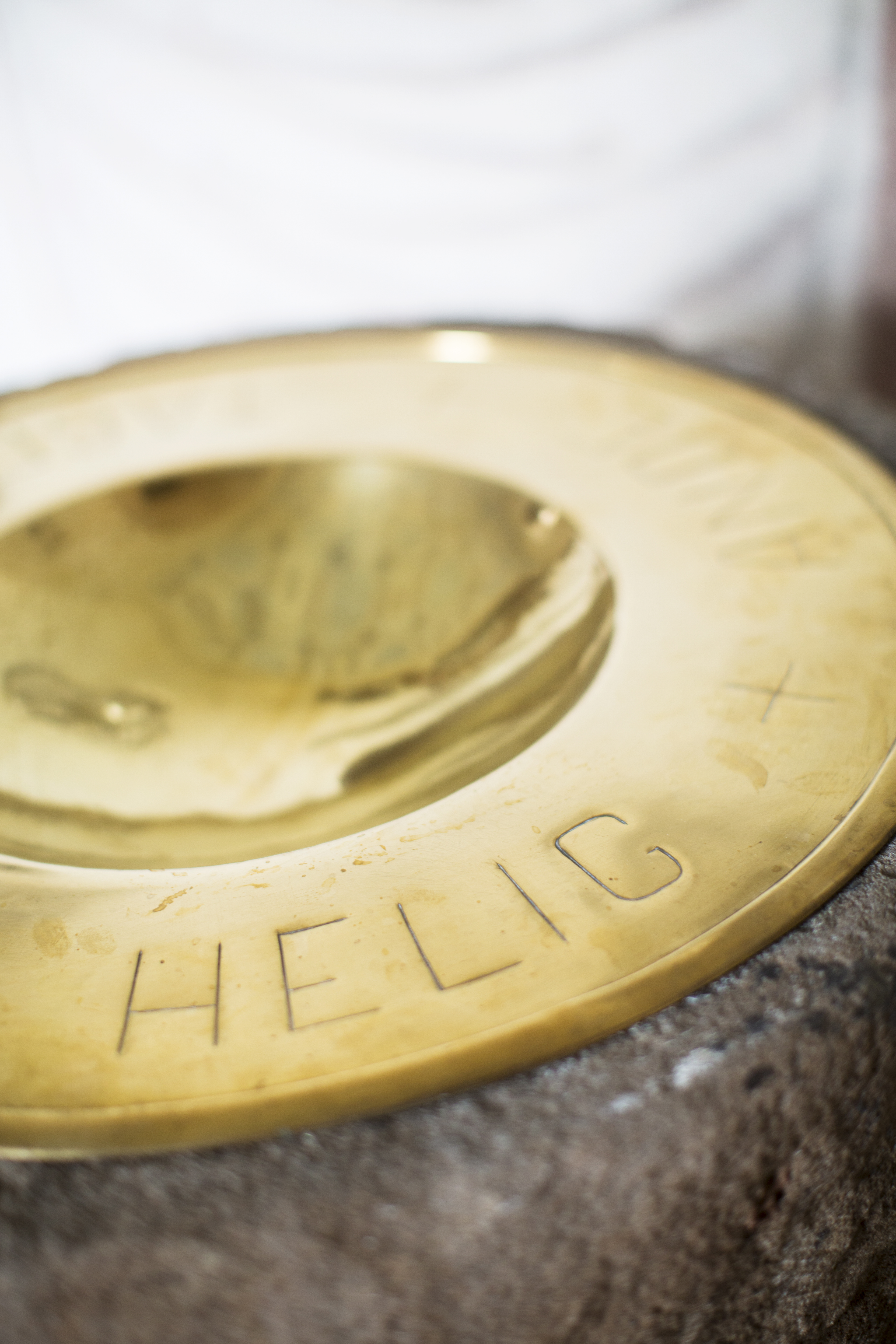 En guldig dopfunt med texten Helig.