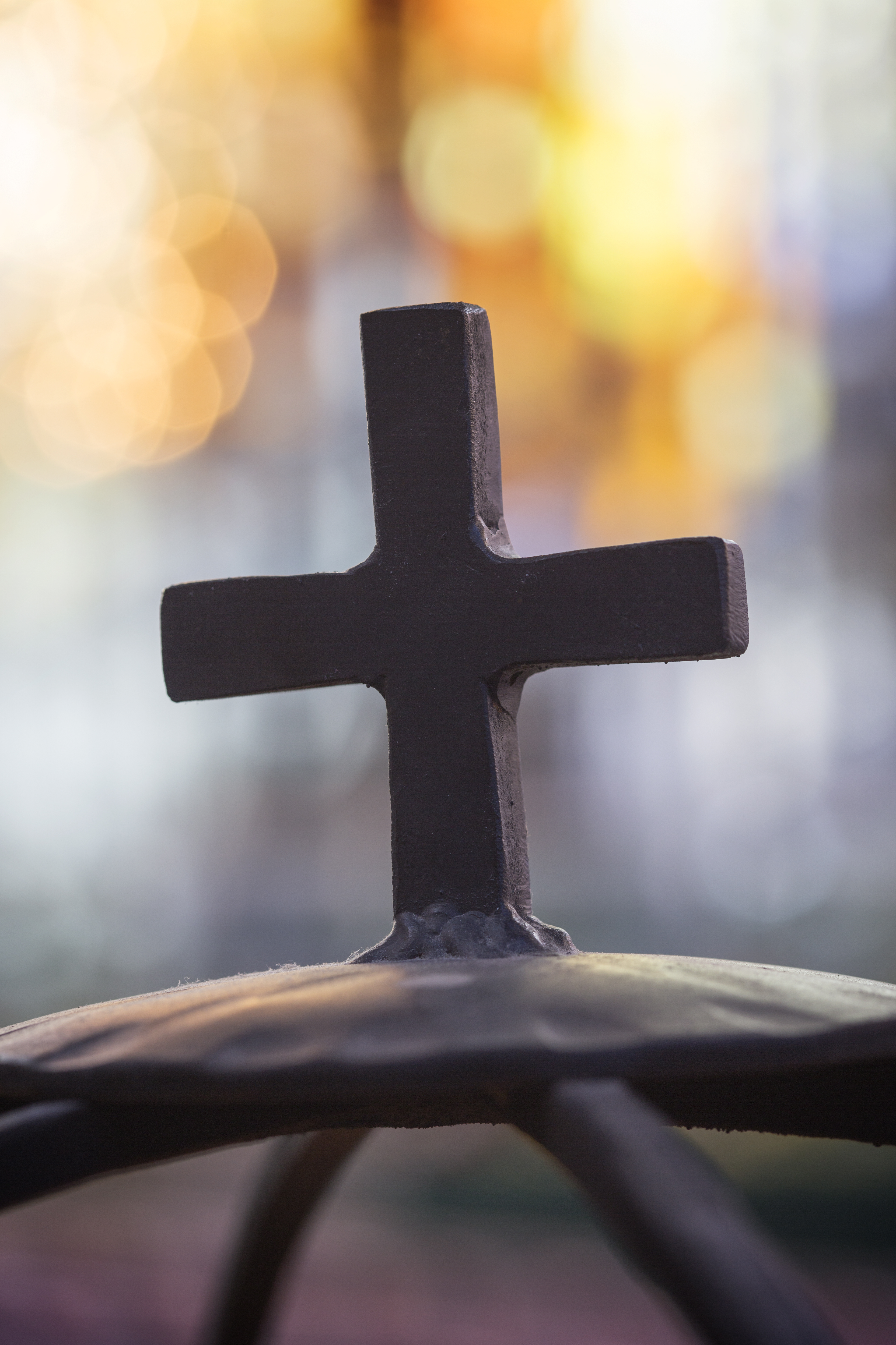 Närbild på ett kors på en ljusbärare.