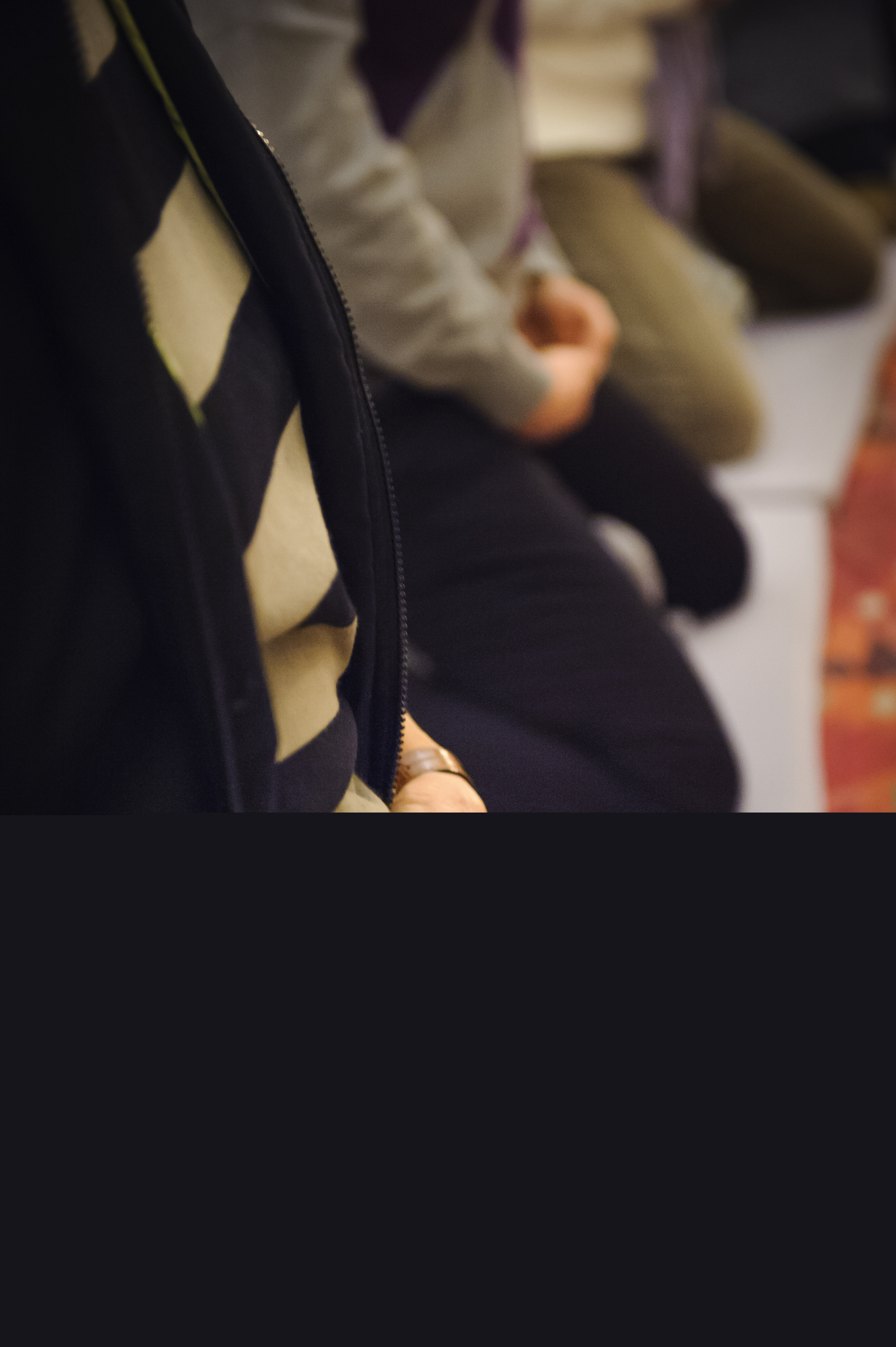 Några personer sitter på knä på golvet med knäppta händer.