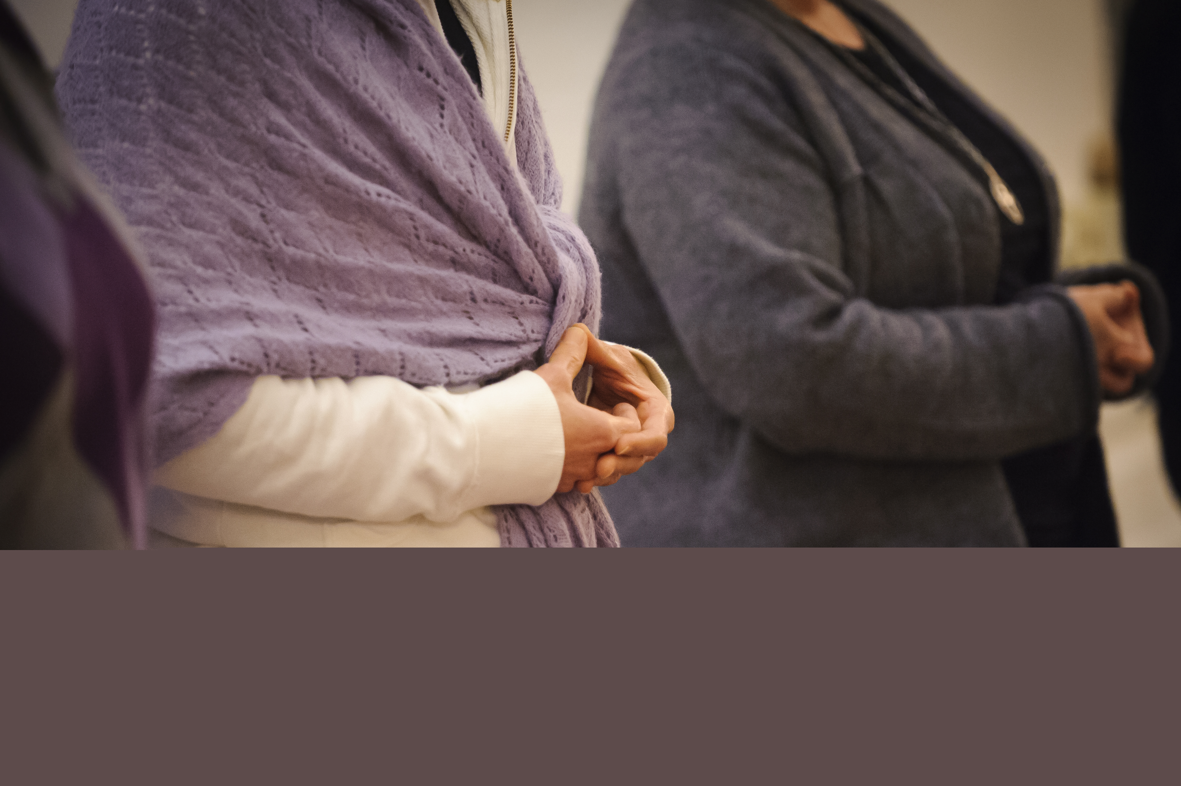 Två personer sitter på knä med knäppta händer.