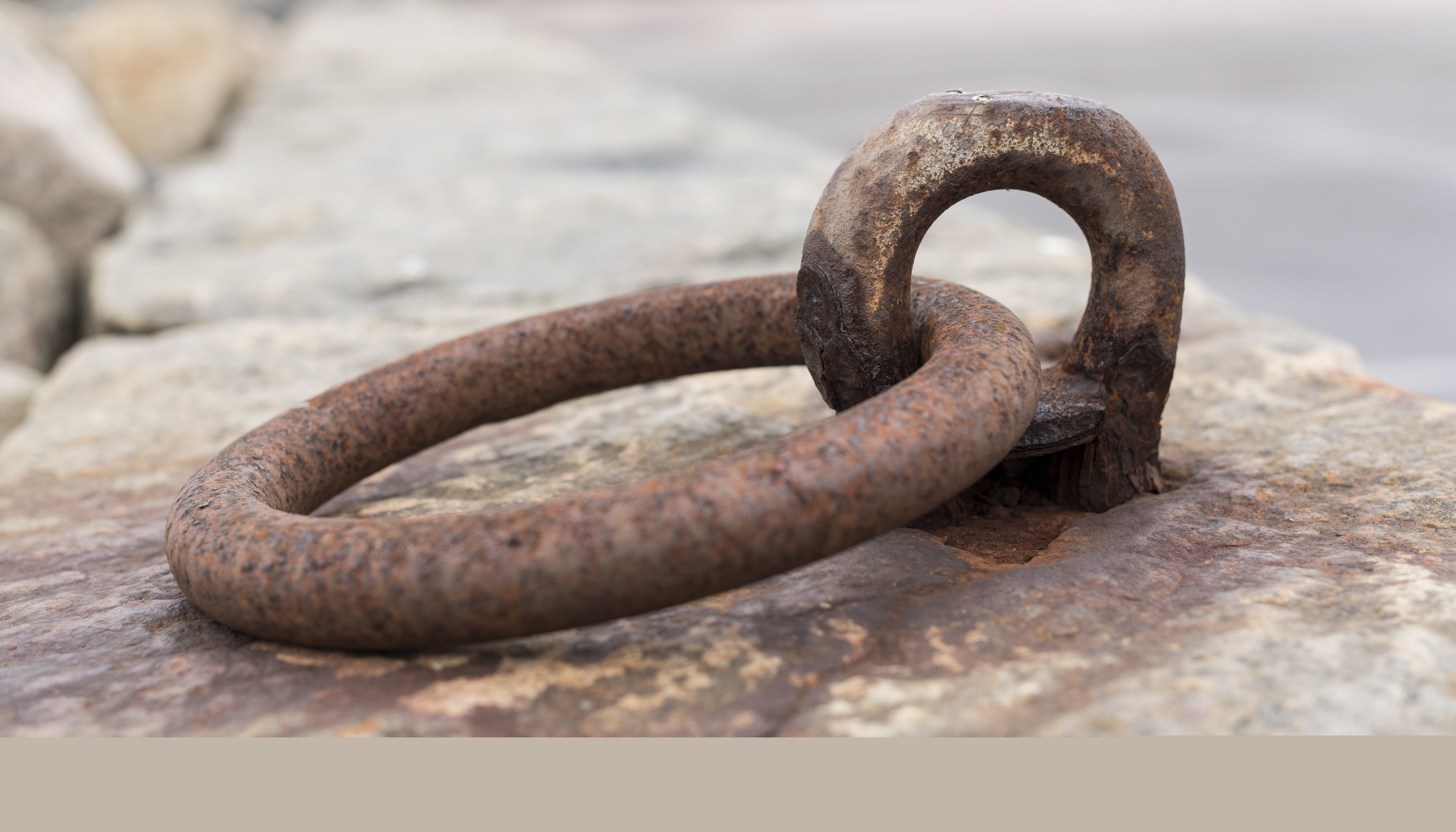 Närbild på en rostig järnring på en kaj.