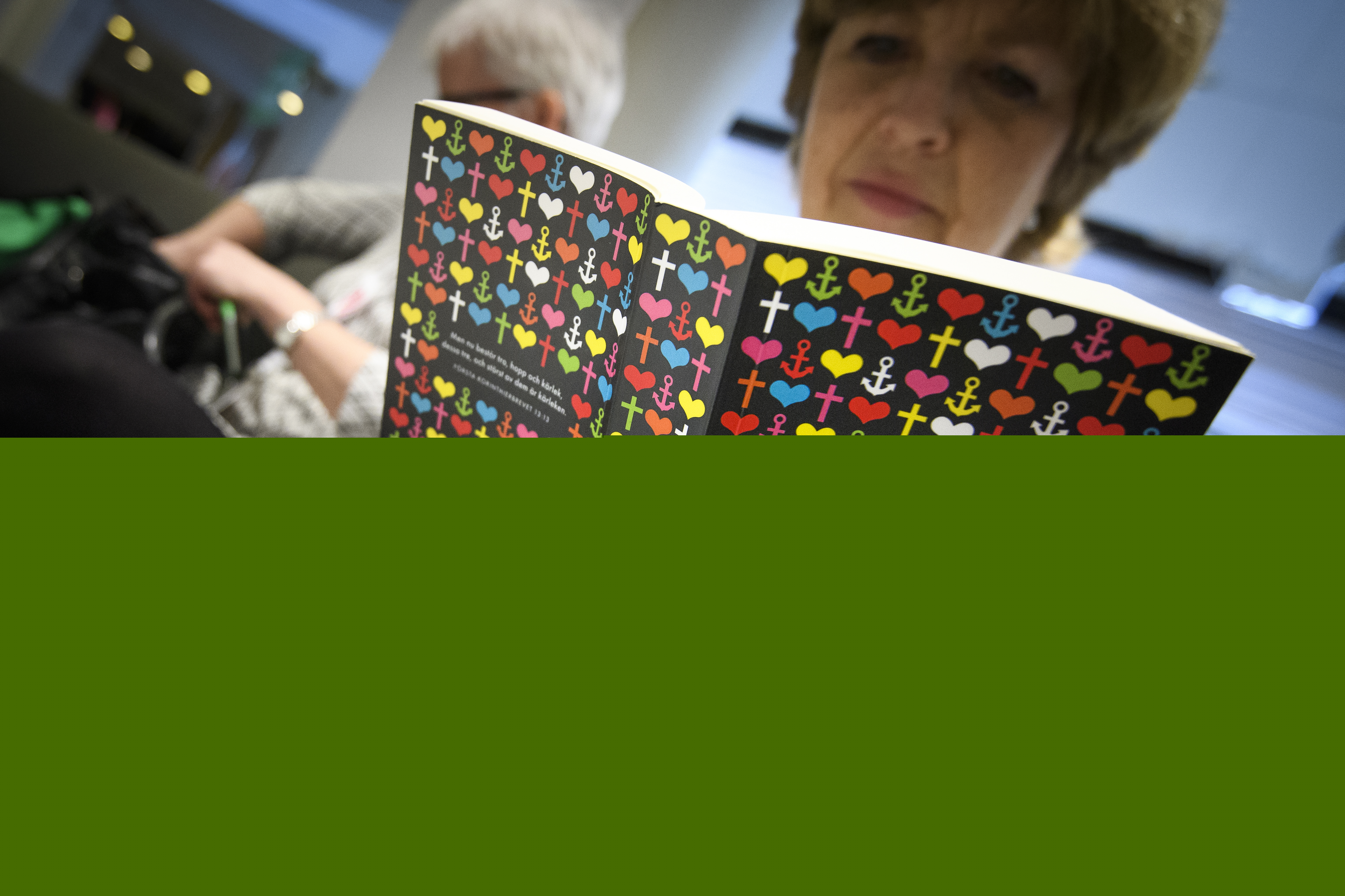 En äldre kvinna läser en bibel.