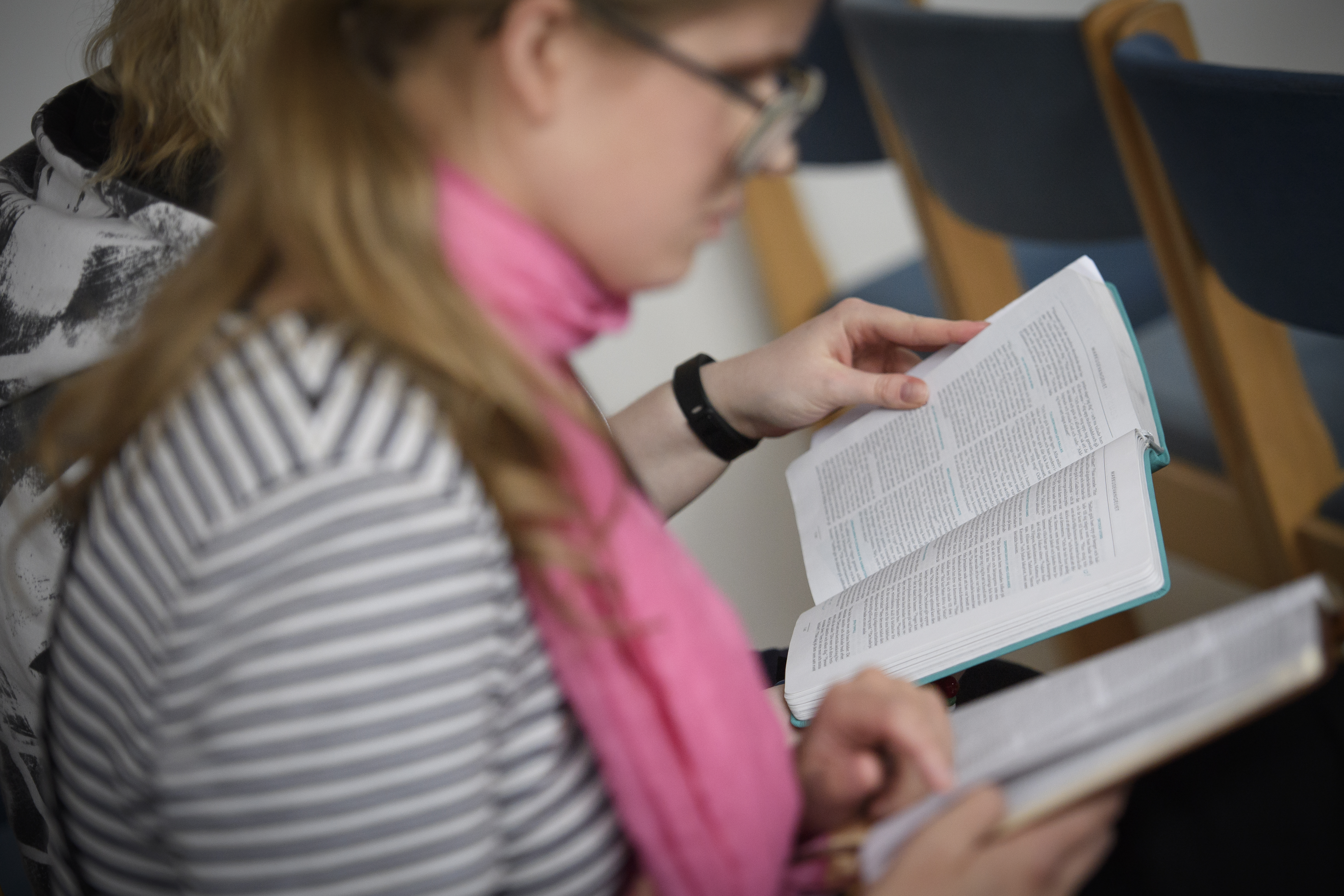 Två personer sitter bredvid varandra och läser varsin bibel.